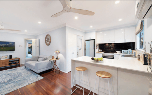 modern living room with grey sofas, interesting interior design elements and a modern white kitchen