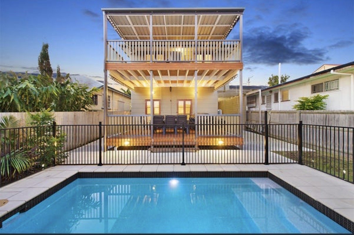 Modern backyard with swimming pool, raised deck and two-storey rear extension