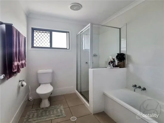 Basic bathroom with shower, bathtub, small vanity and neutral tiles