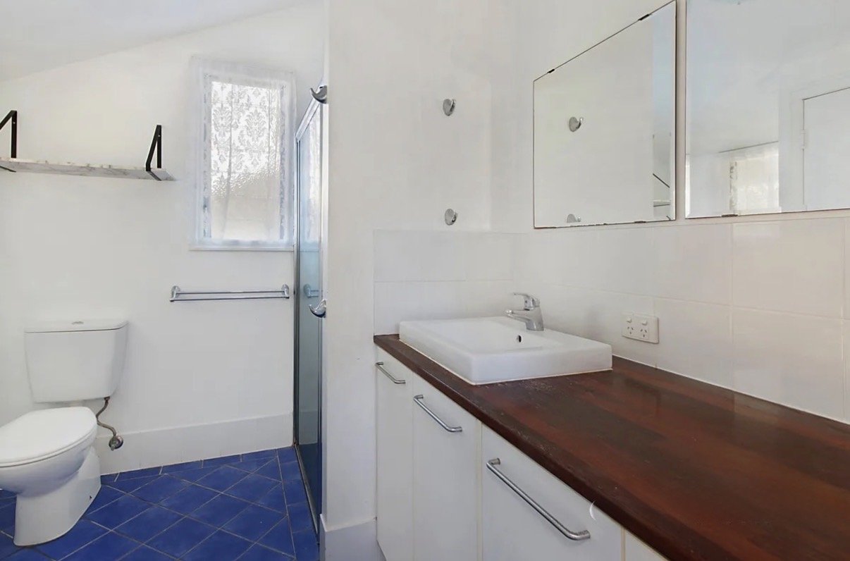 Basic bathroom with small vanity, mirror cabinet and blue floor tiles