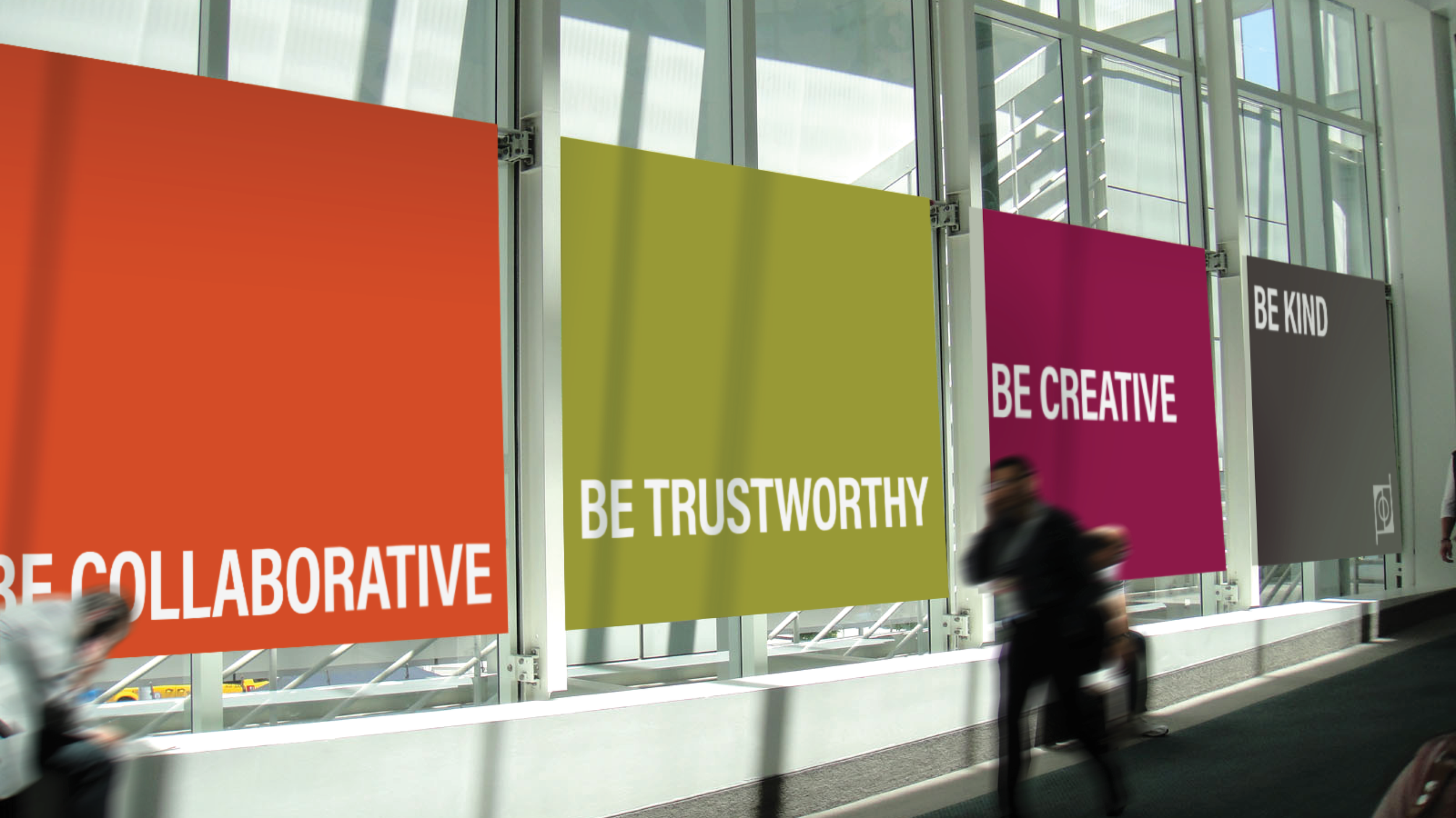 Billboards with motivational messages in an airport, including "Be Collaborative," "Be Trustworthy," "Be Creative," and "Be Kind."