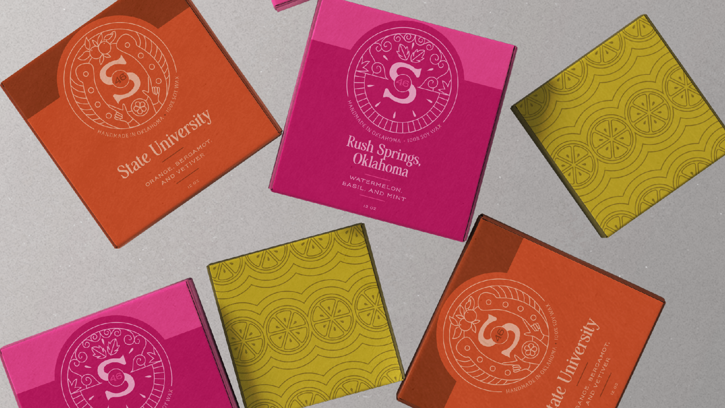 Multiple colorful soap boxes on a gray surface, including orange boxes labeled 'State University', pink boxes labeled 'Rush Springs, Oklahoma', and yellow boxes with a citrus slice pattern.