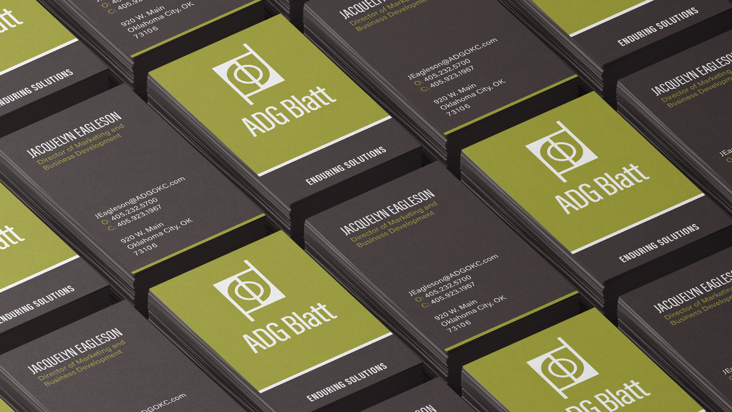 A stack of business cards for ADG Blatt, featuring a green, black, and white design with a logo, the name Jacquelyn Eagleson, her title as Director of Marketing and Business Development, and contact information including email, phone, and address.