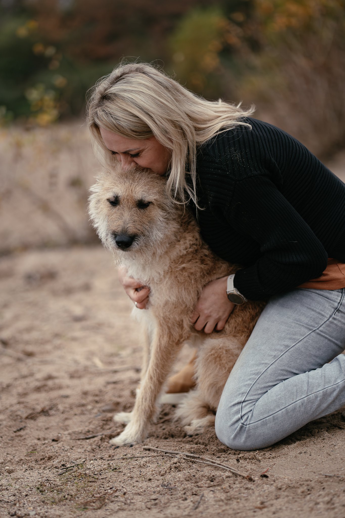 Frau umarmt ihren Schäferhund Laekenois liebevoll.