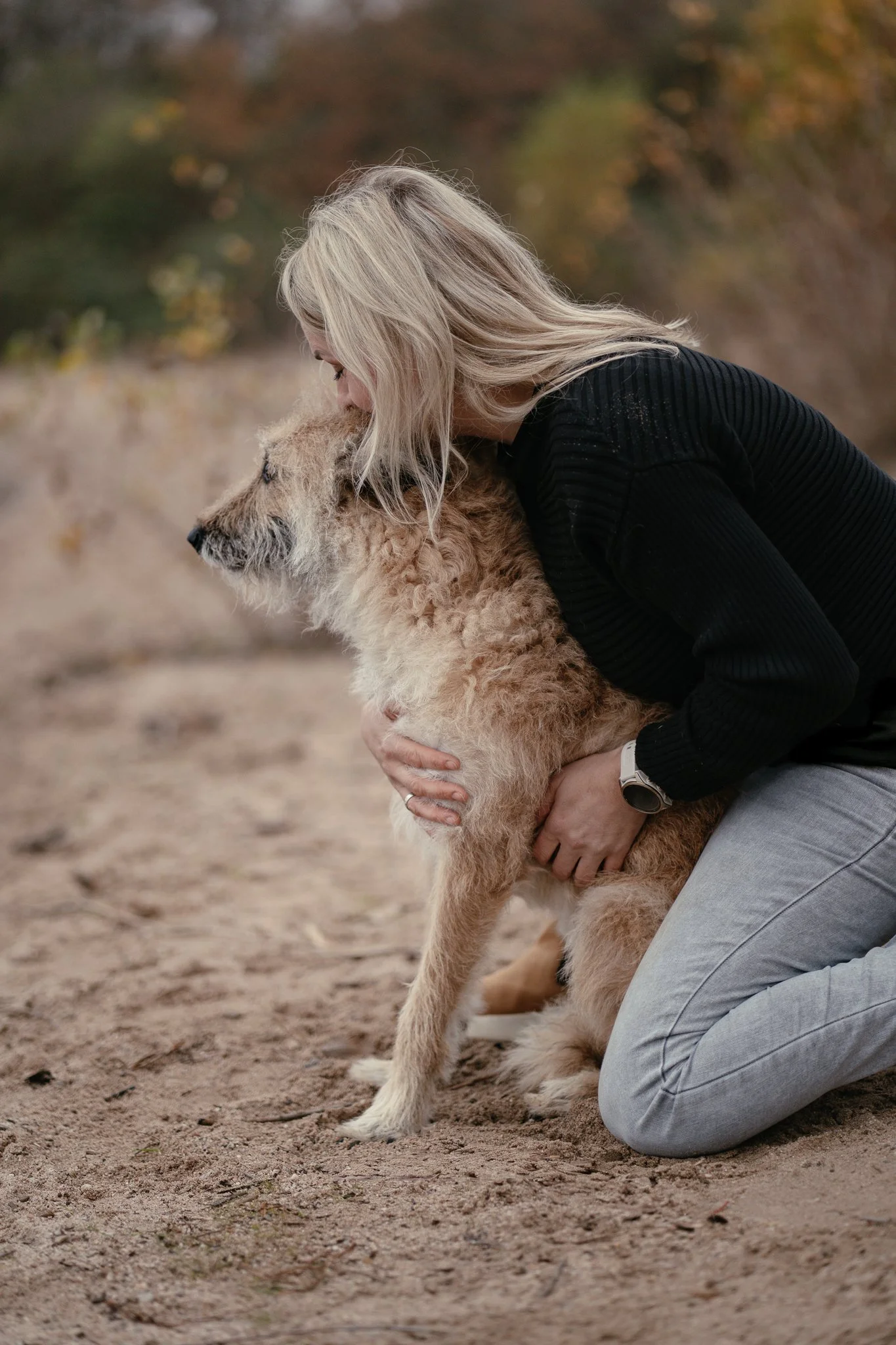 Schäferhund Laekenois kuschelt mit Frauchen am Strand