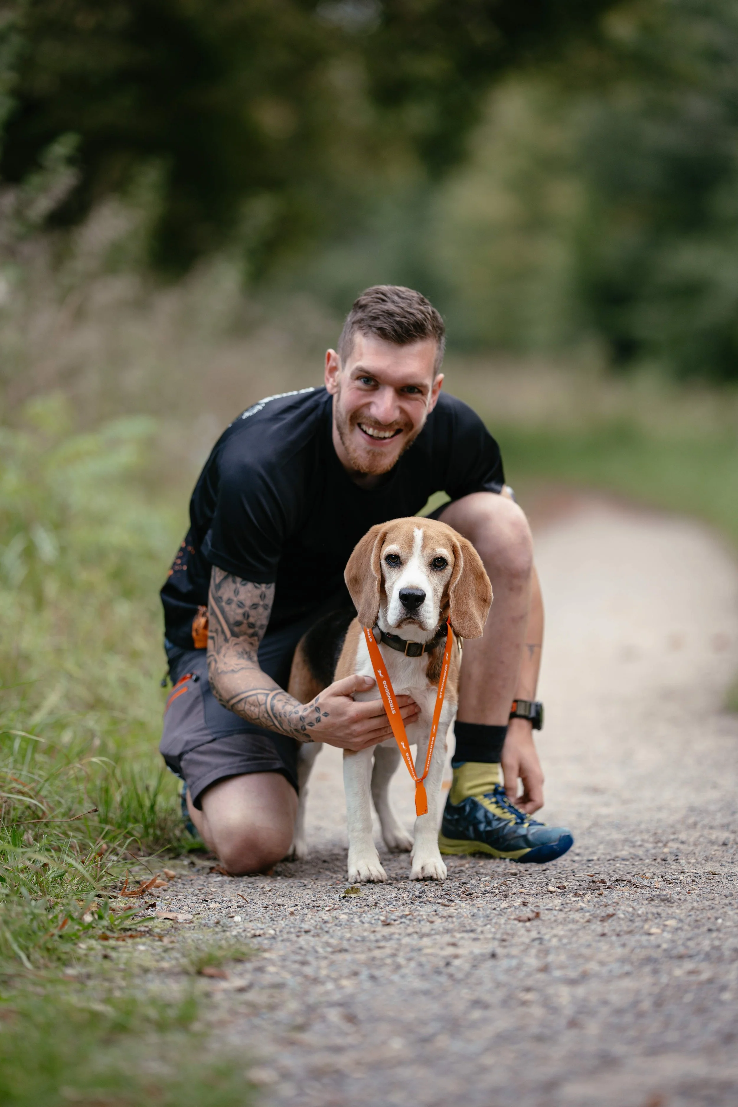 Ein Mann hält glücklich seinen Beagle Rüden.