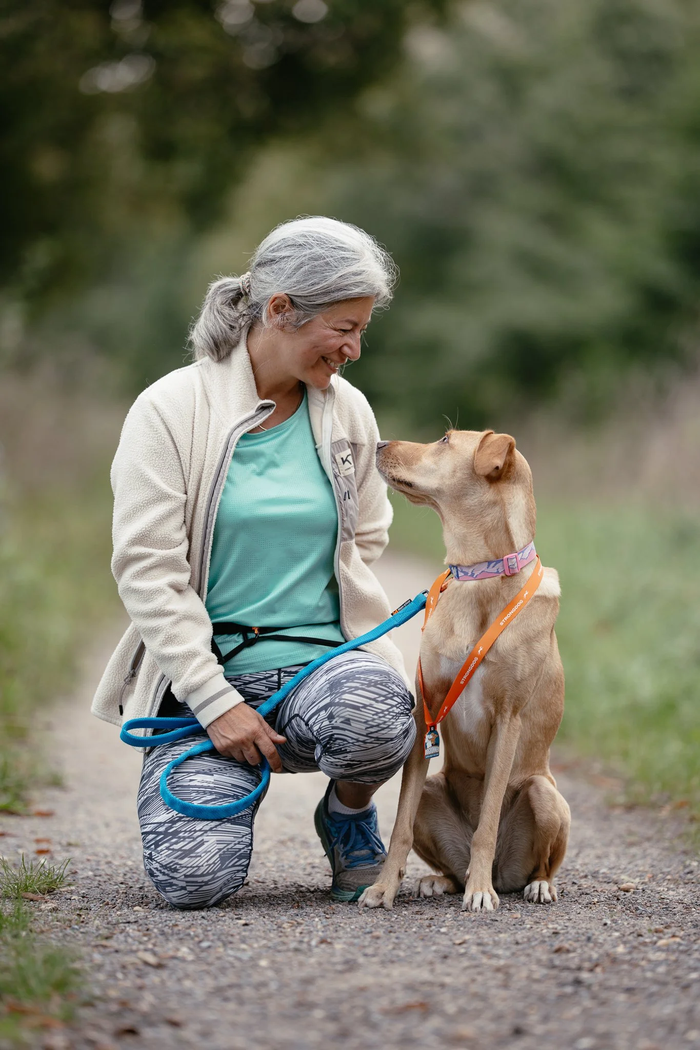 Eine ältere Frau und ein Hund, die sich liebevoll anschauen.