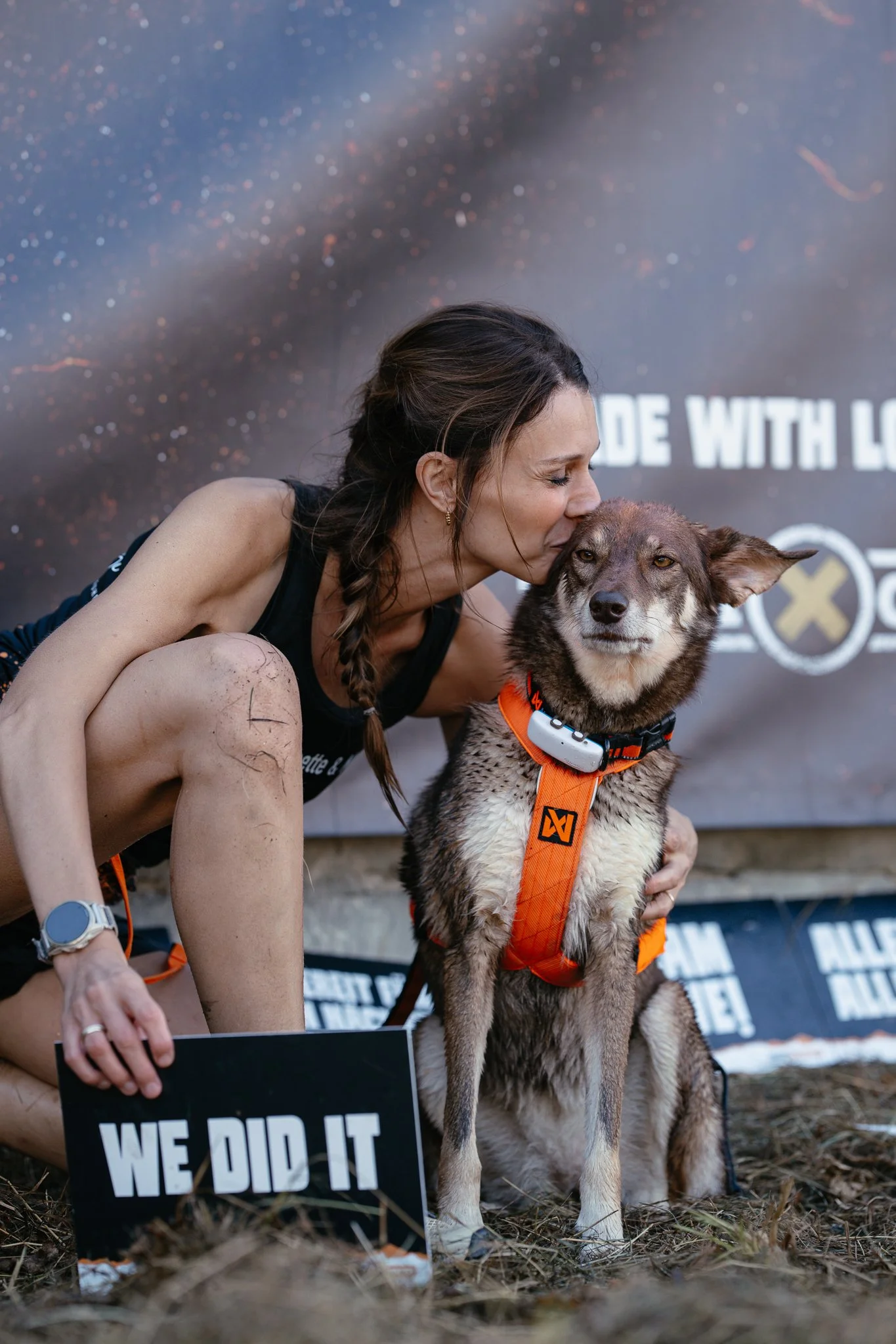 Frau küsst ihren Hund nach einem Lauf, beim TOUGH HUNTER.