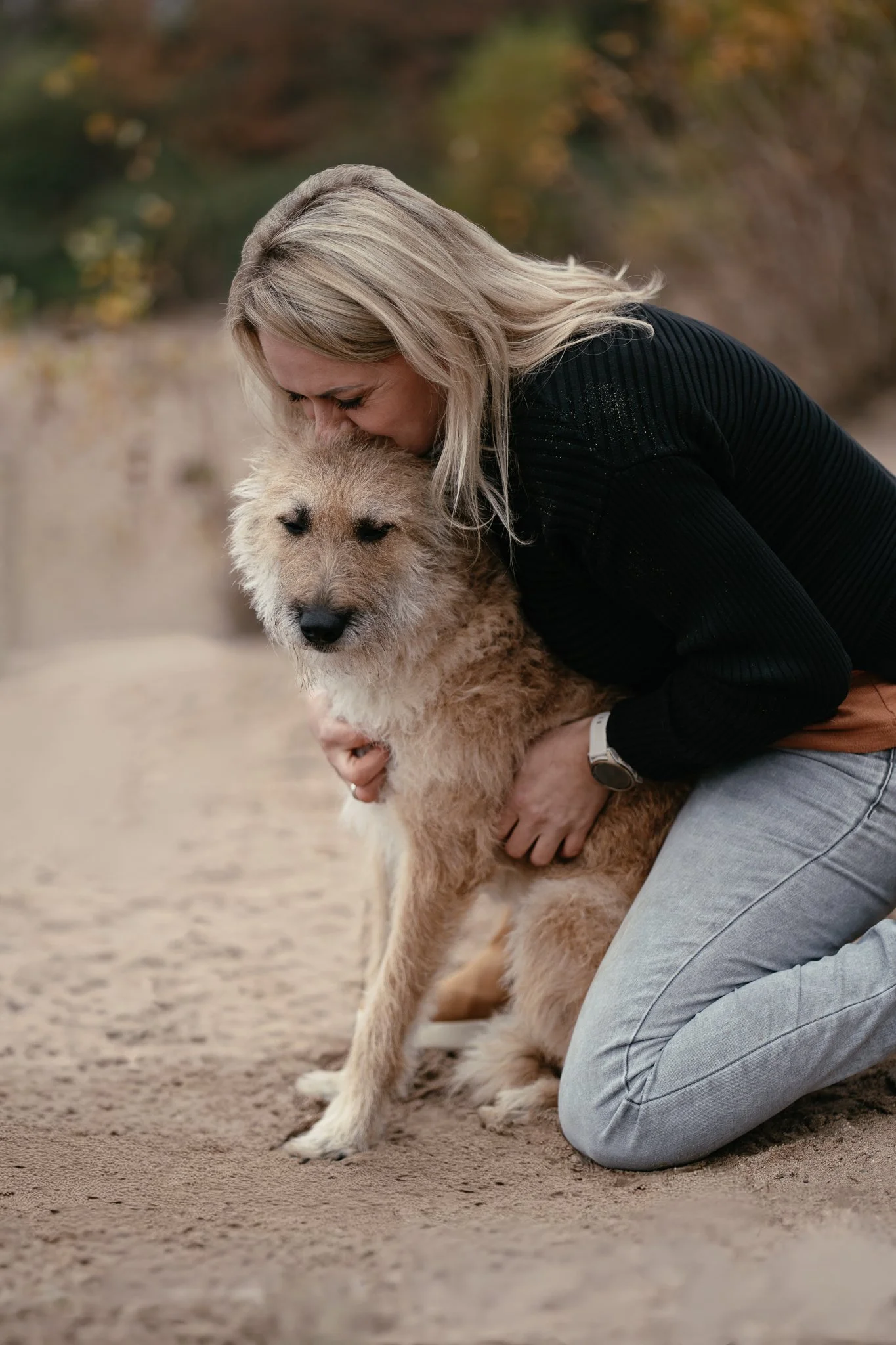 Frau umarmt ihren Schäferhund Laekenois liebevoll.