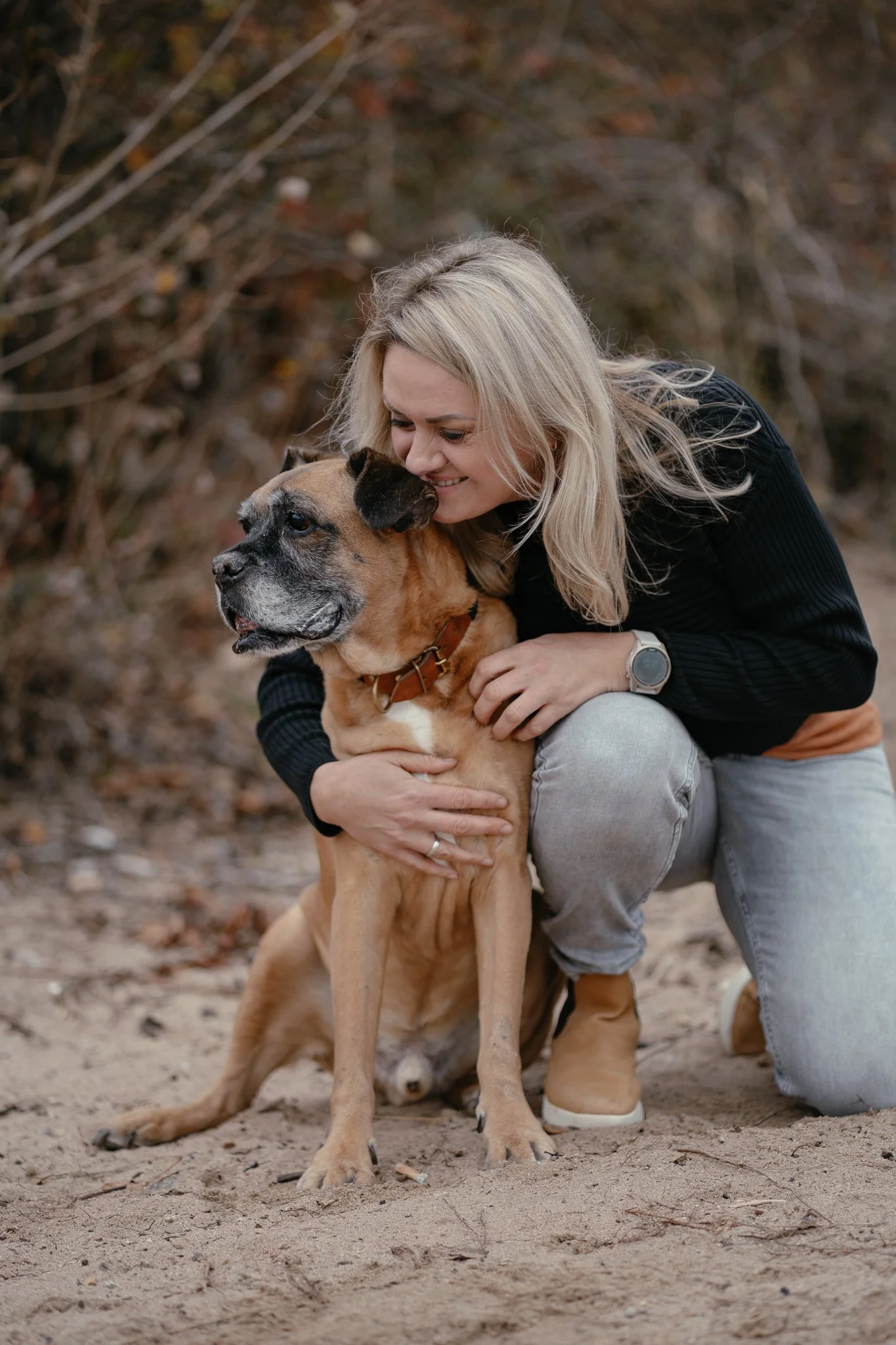 Mischlingsrüde kuschelt mit Frauchen am Strand