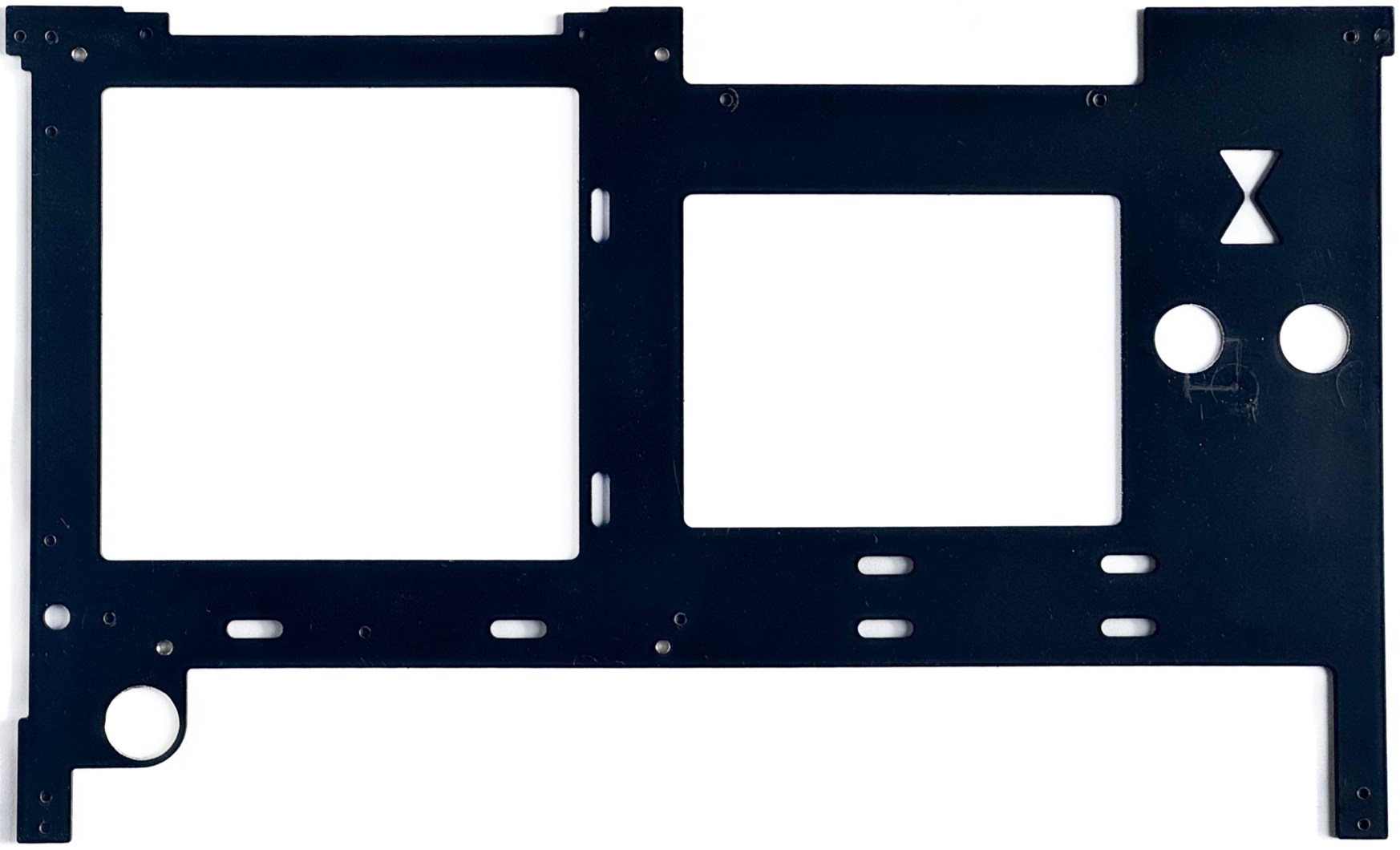 A black metal computer mounting plate with cutouts for components and screw holes.