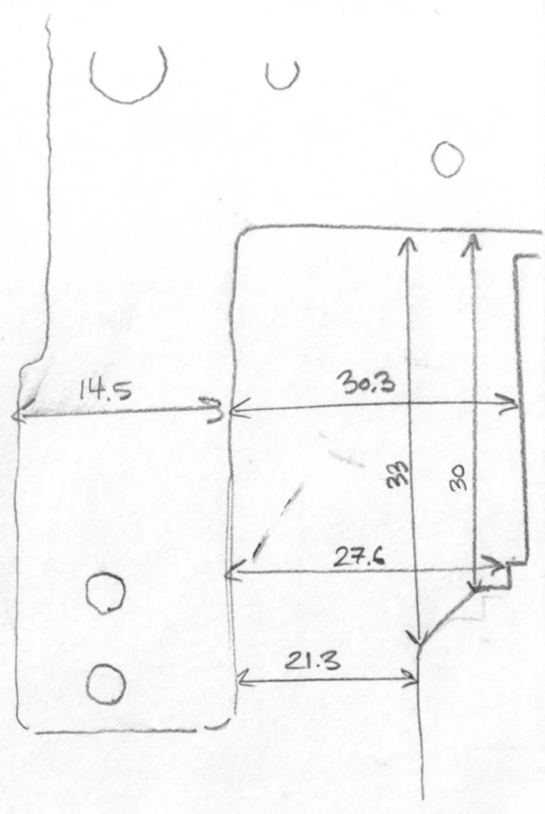 Hand-drawn sketch of a connected structure with detailed measurements in centimeters, including a rectangle measuring 30.3 by 33 cm, a smaller section measuring 27.6 by 23 cm, and additional dimensions of 14.5, 21.3, and 30 cm. Circles are placed around the drawing as indicators or reference points.