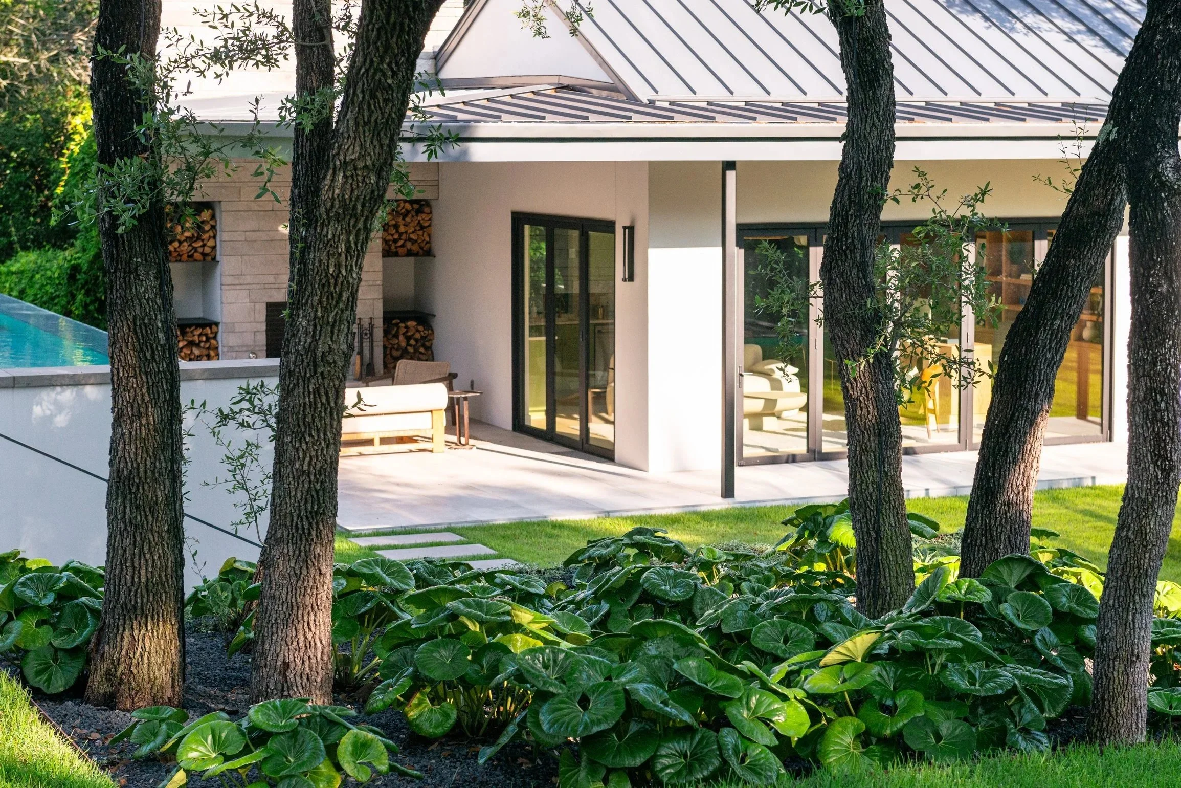 Swaths of bright green, waxy gopher plant punctuated by pops of purple salvia create a bold, sculptural tier of planting.