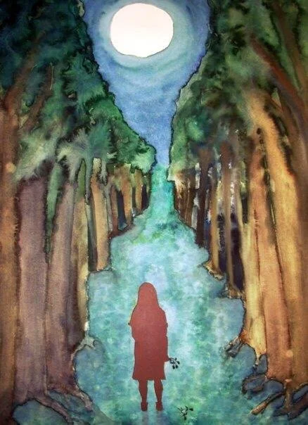 Young girl standing on a forest path