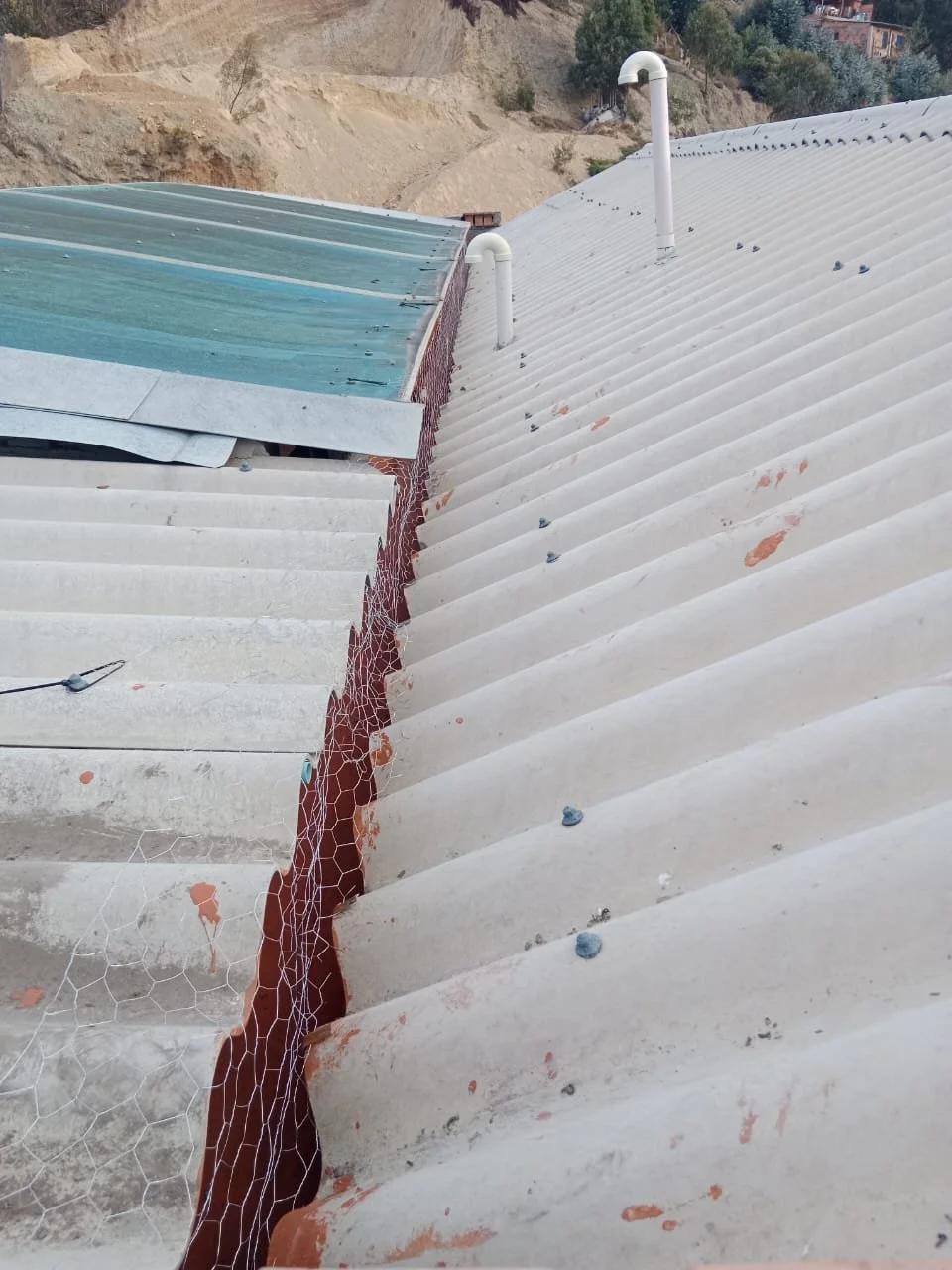 Vista del techo de una construcción con una rajadura. La rajadura está reforzada con malla metálica y se observa un cable delgados en la parte baja.