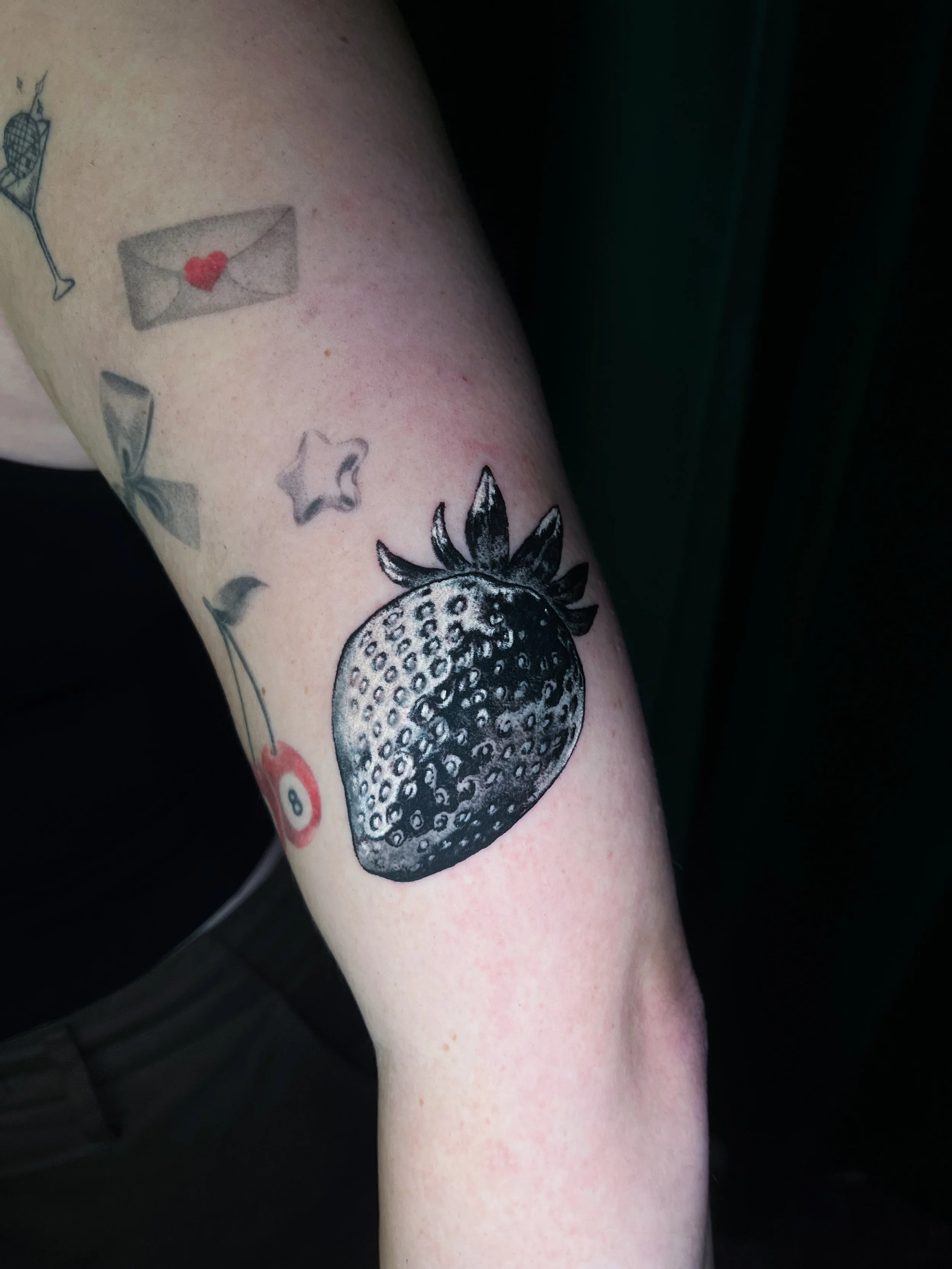 Tattoo of a pomegranate fruit on a person's arm.