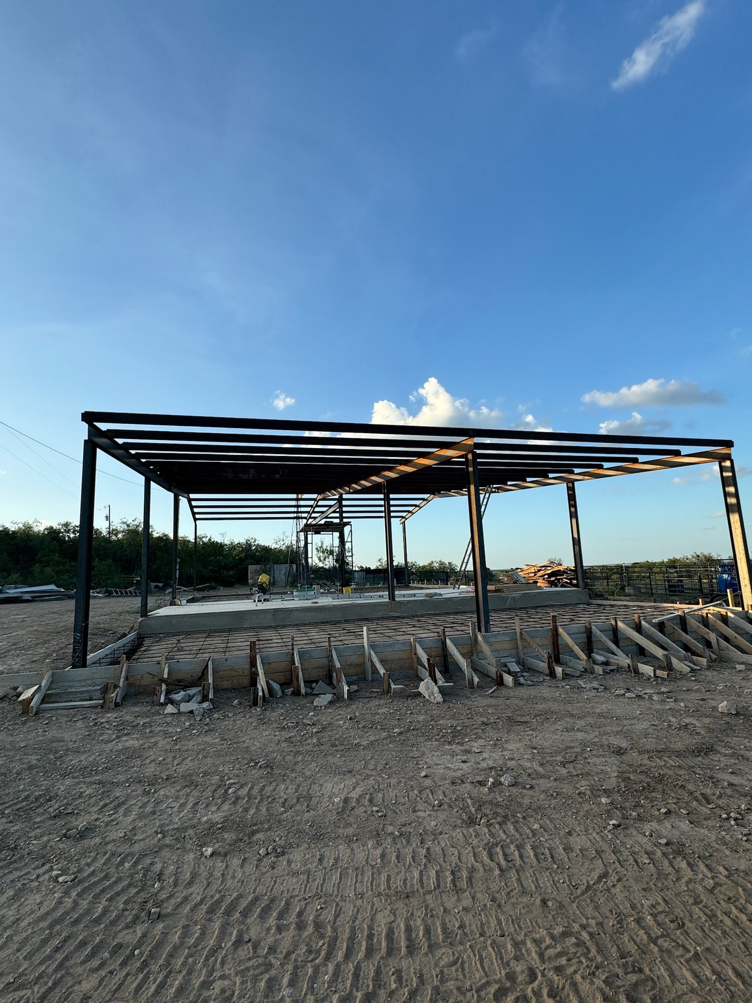 Construction site with a partially built structure and a clear blue sky.