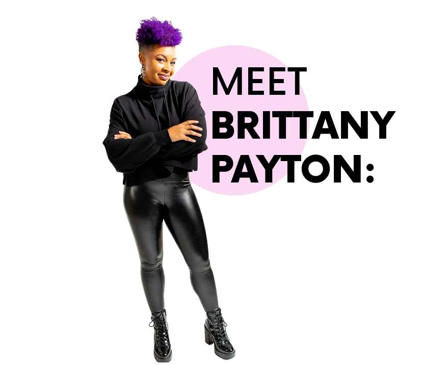 A woman with purple hair, wearing a black turtleneck and shiny black pants, standing with arms crossed in front of a pink graphic background with black and purple text that says 'Meet Britta Payt'.