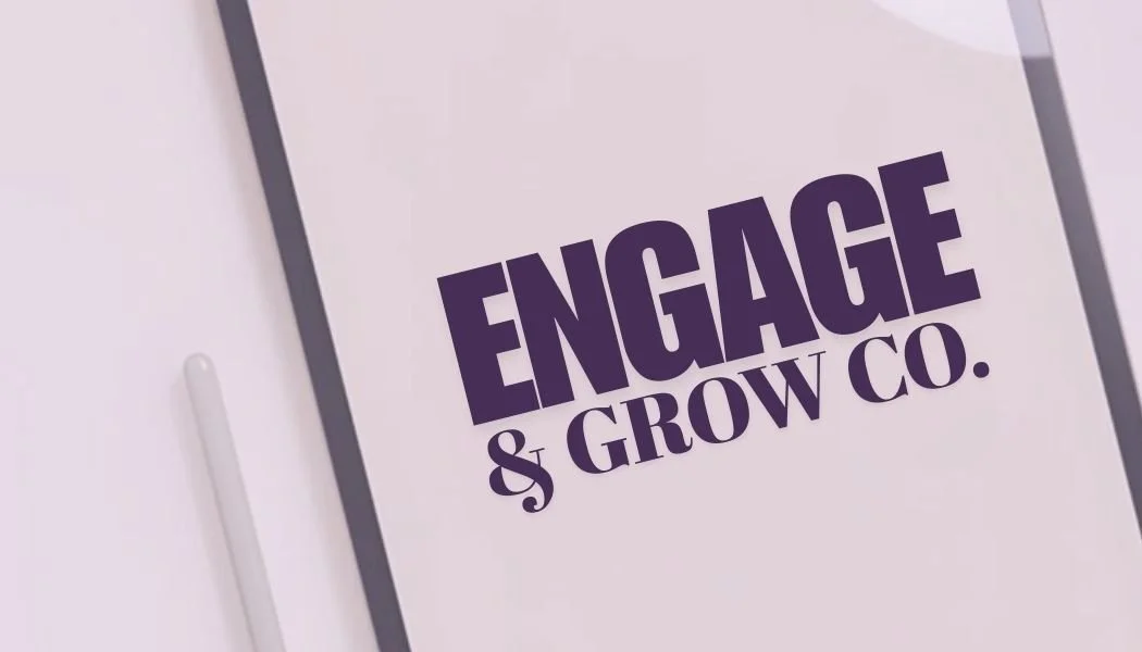 Close-up of a white surface with a sign displaying bold purple text that reads "ENGAGE & GROW CO."