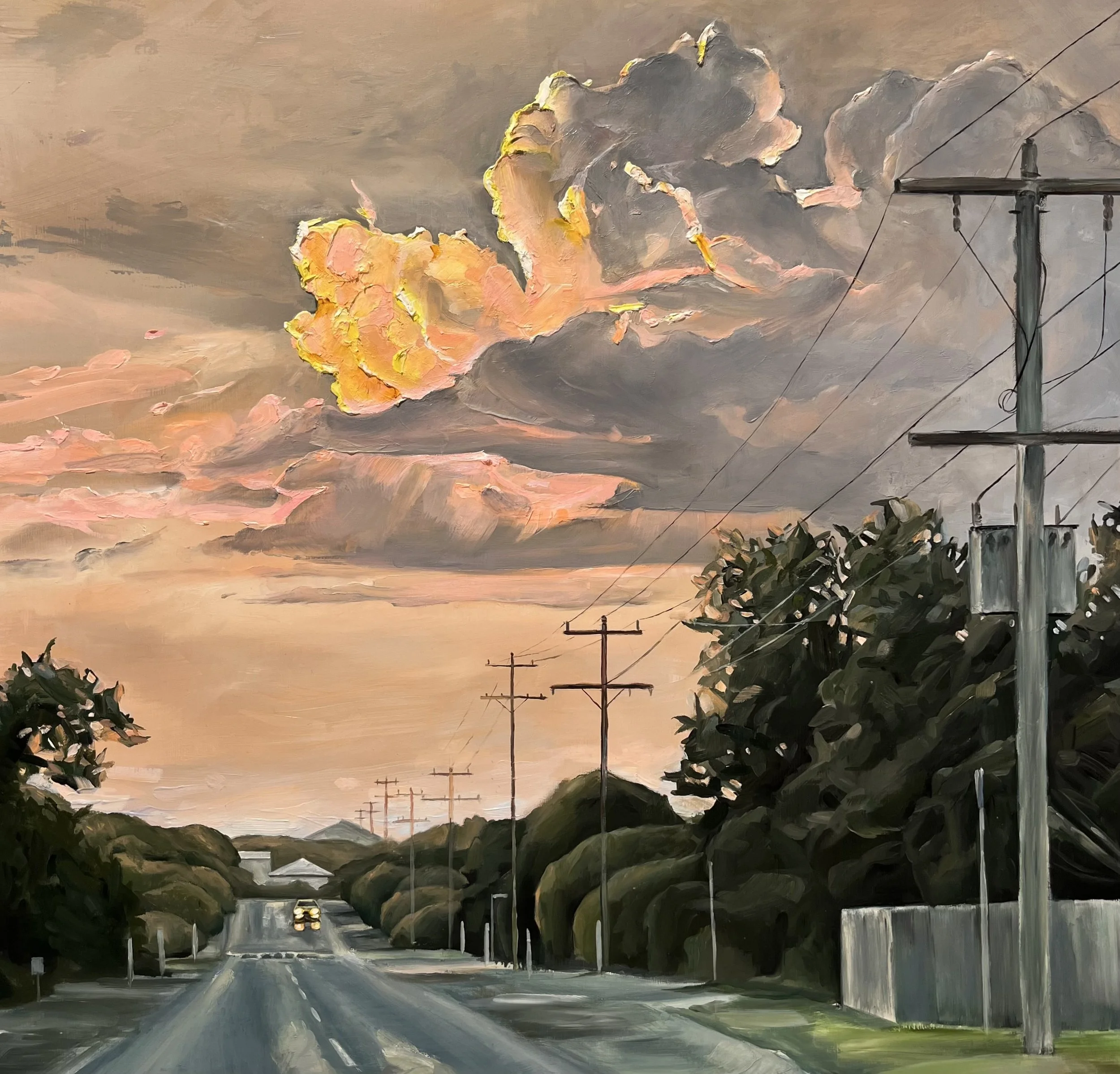 Sunset over a rural road with power lines and lush trees on both sides, with colorful clouds in the sky. By Jen Darcy