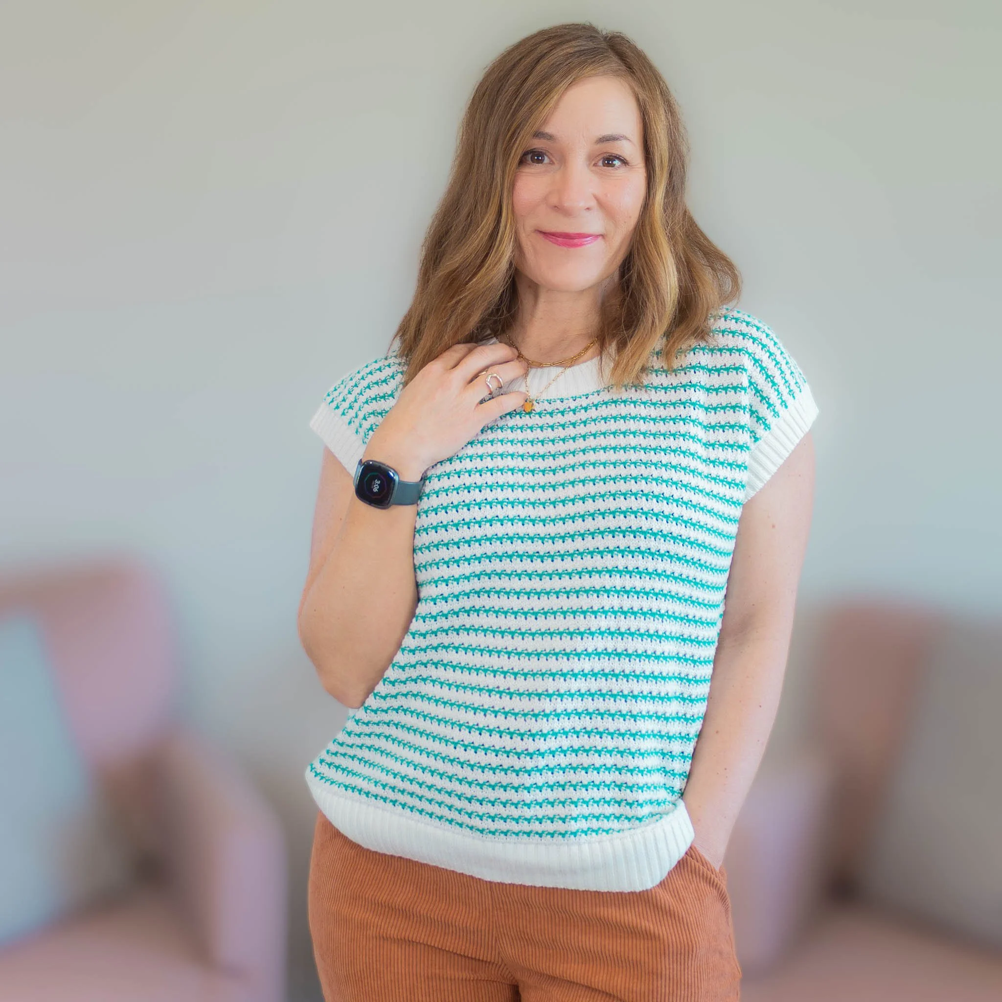 woman looking at camera wearing green and white striped short sleeve sweater