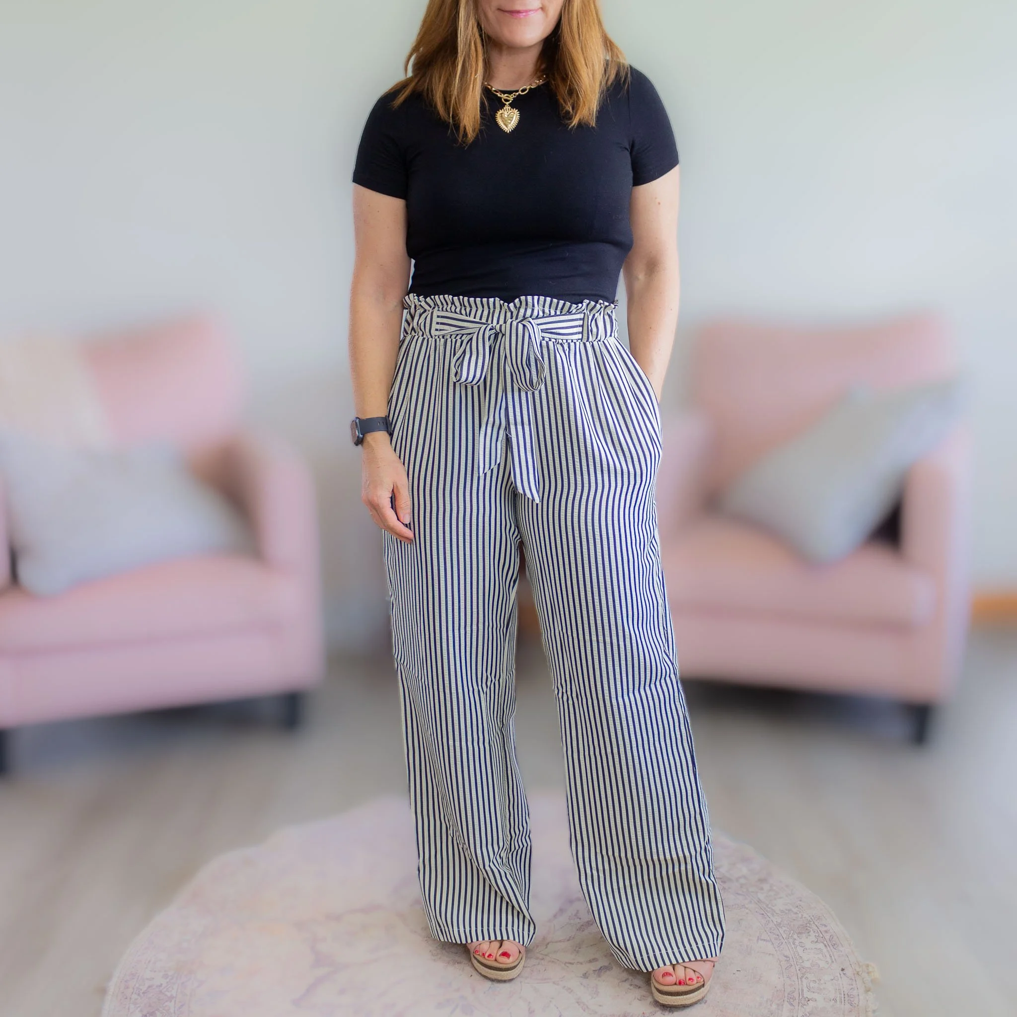 woman from chin down wearing black and tan striped pants
