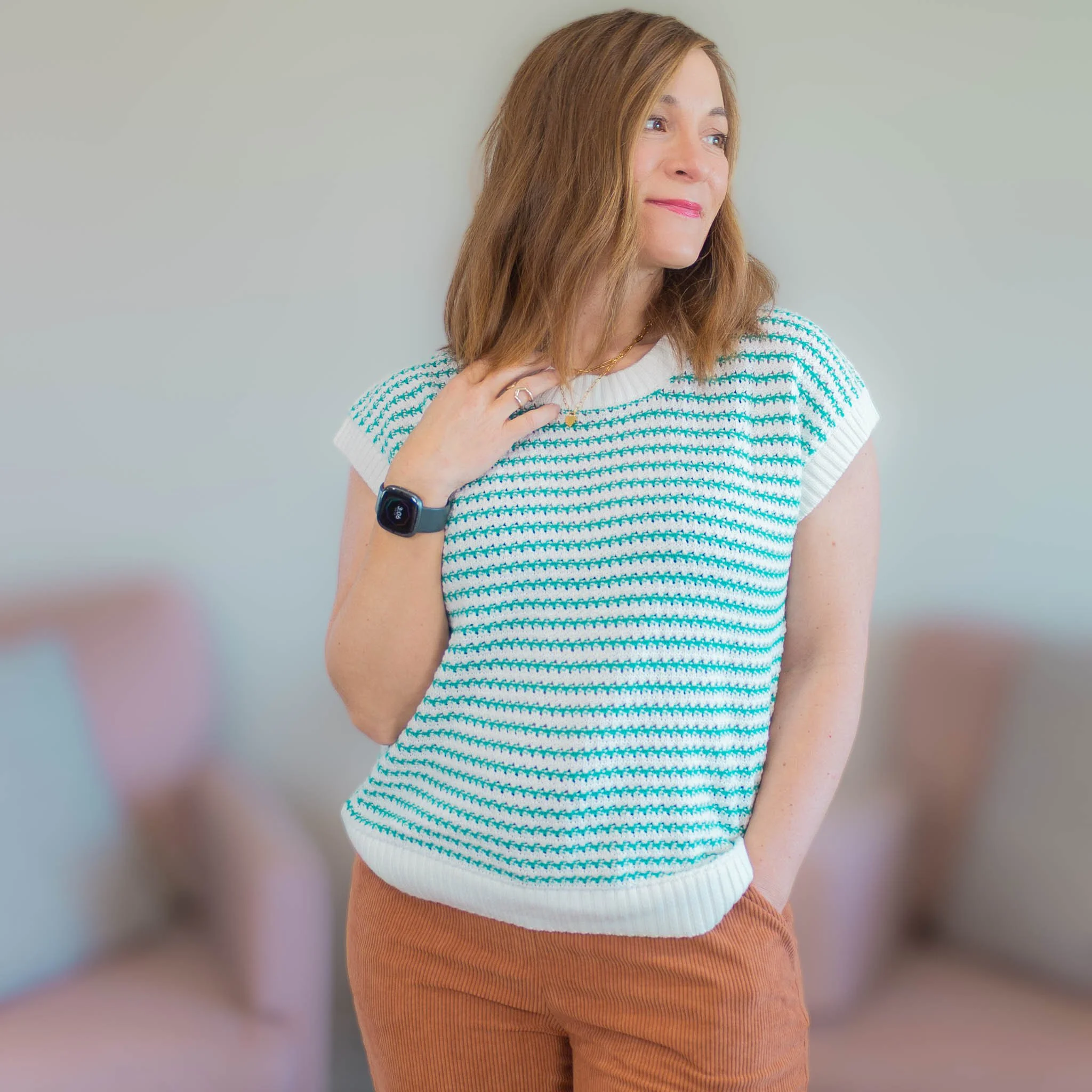 woman looking to the side wearing green and white striped sweater