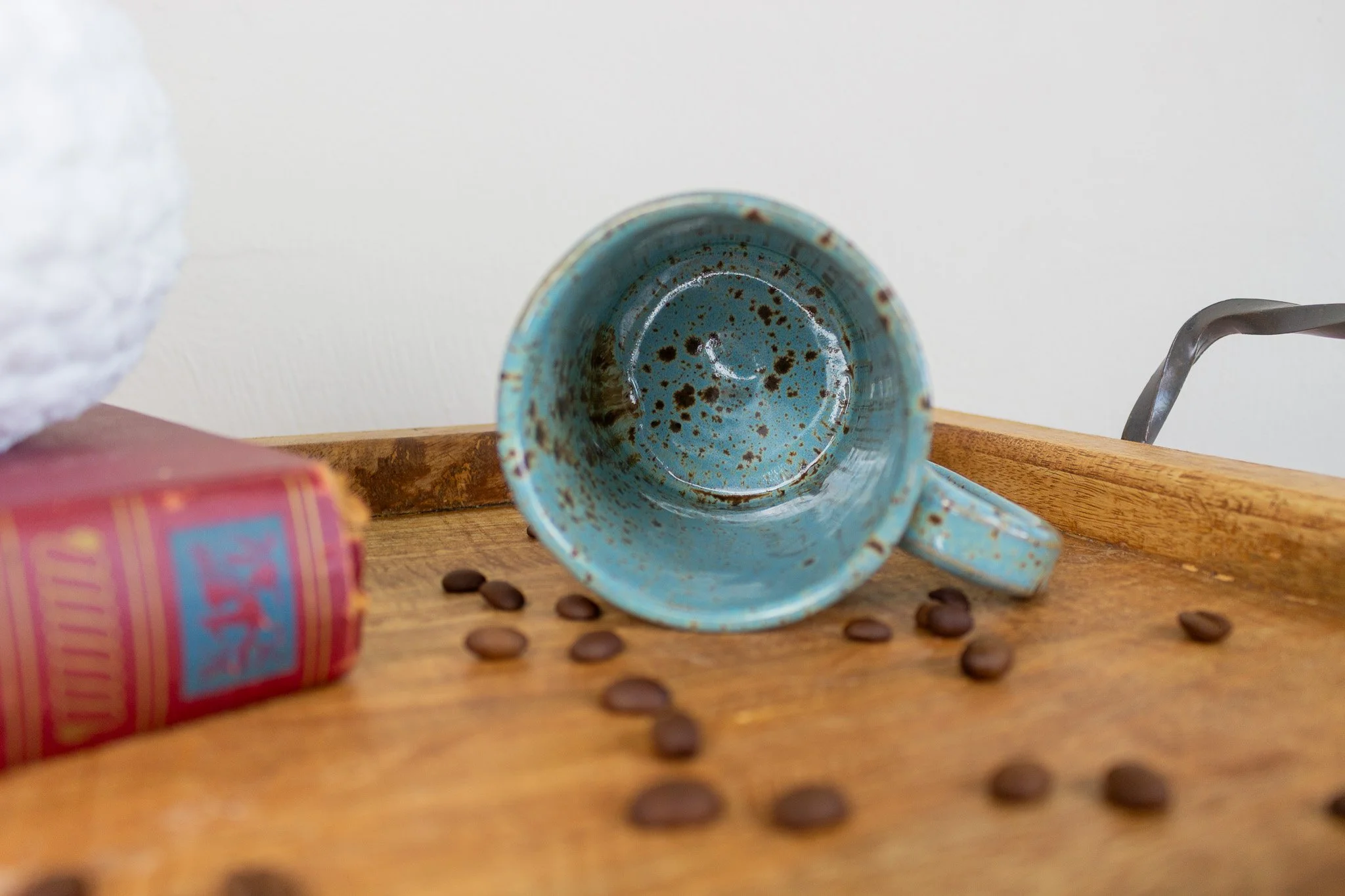 rooster mug laying on its side showing the turquoise and speckled interior.