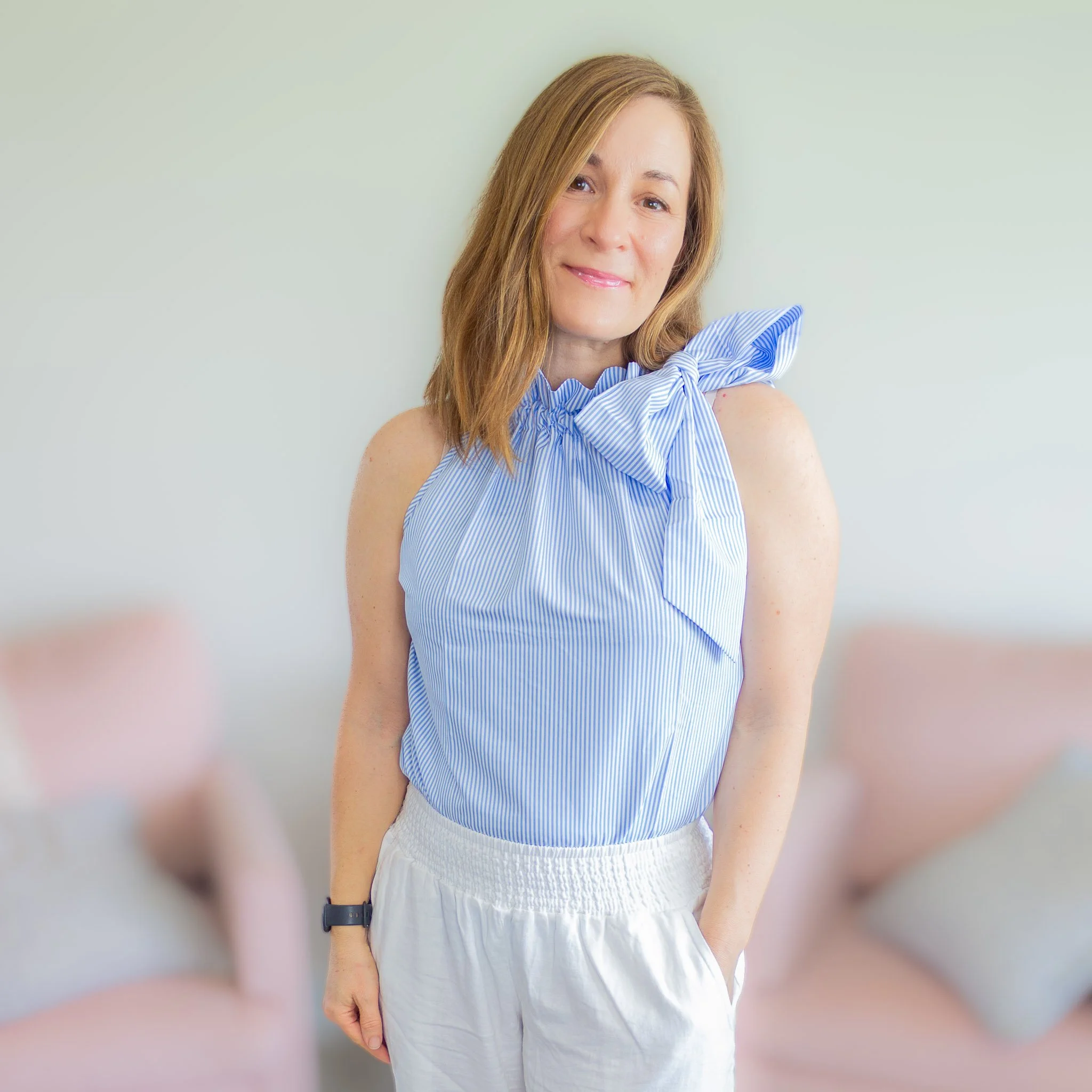 woman from waist up wearing blue and white striped top.