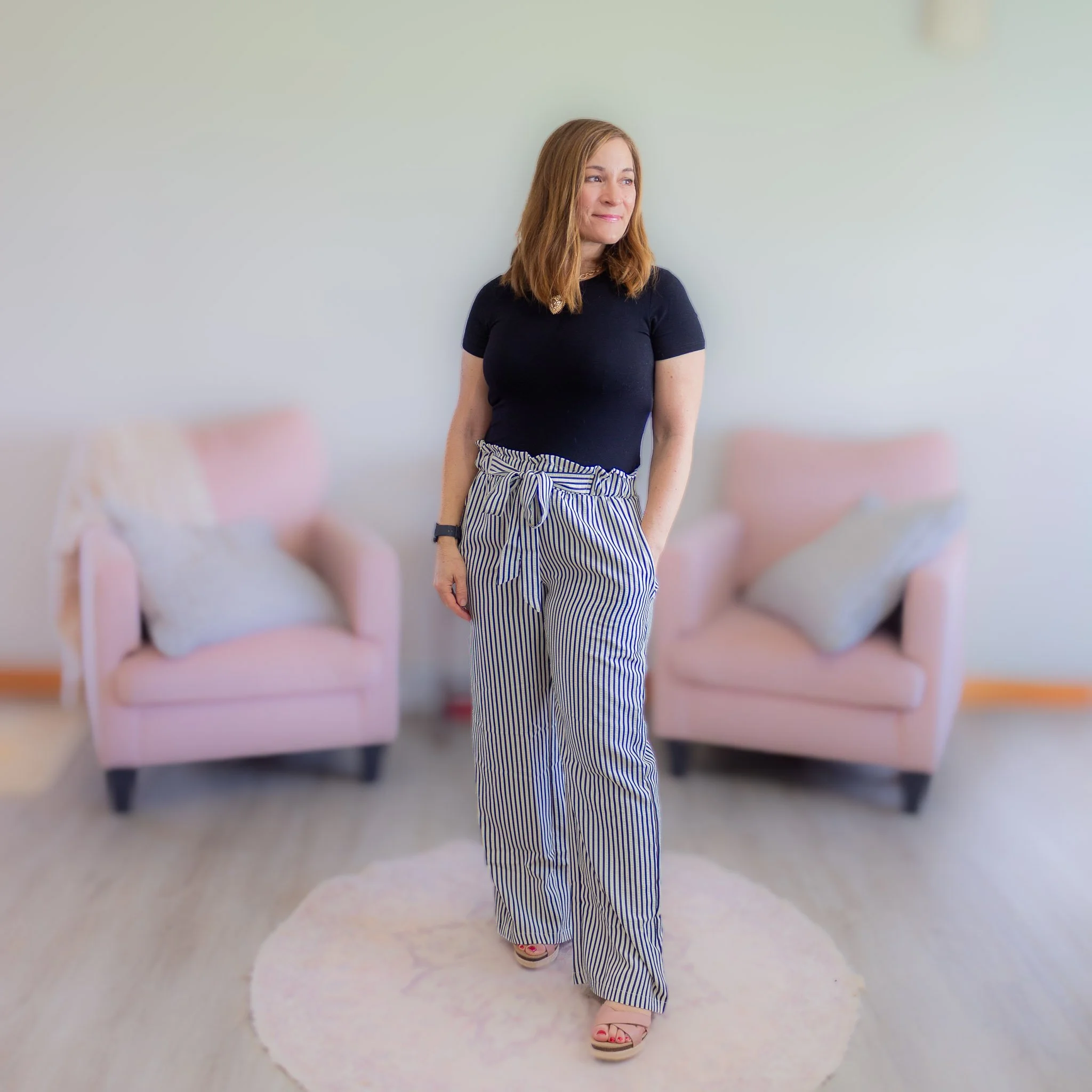 woman wearing black and white striped pants with tie waist and black shirt.