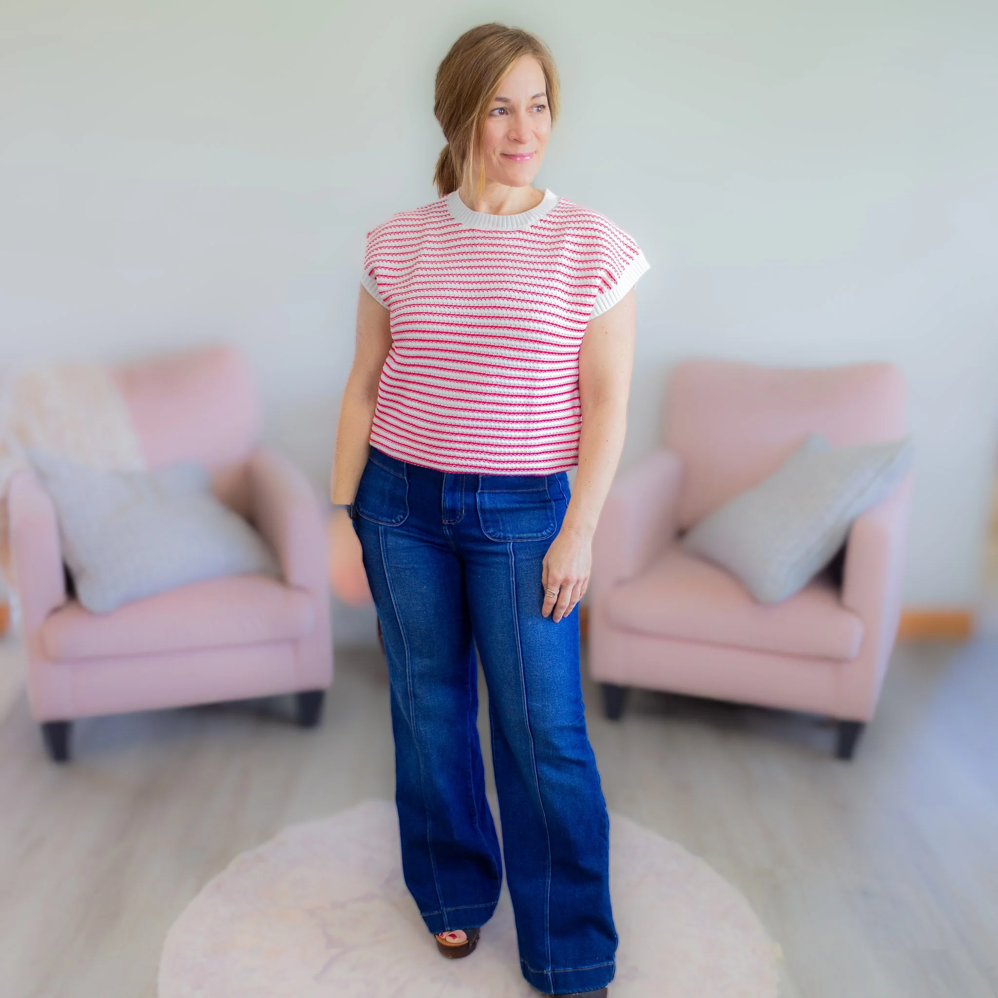 woman wearing red and white striped short sleeve sweater top with dark jeans.