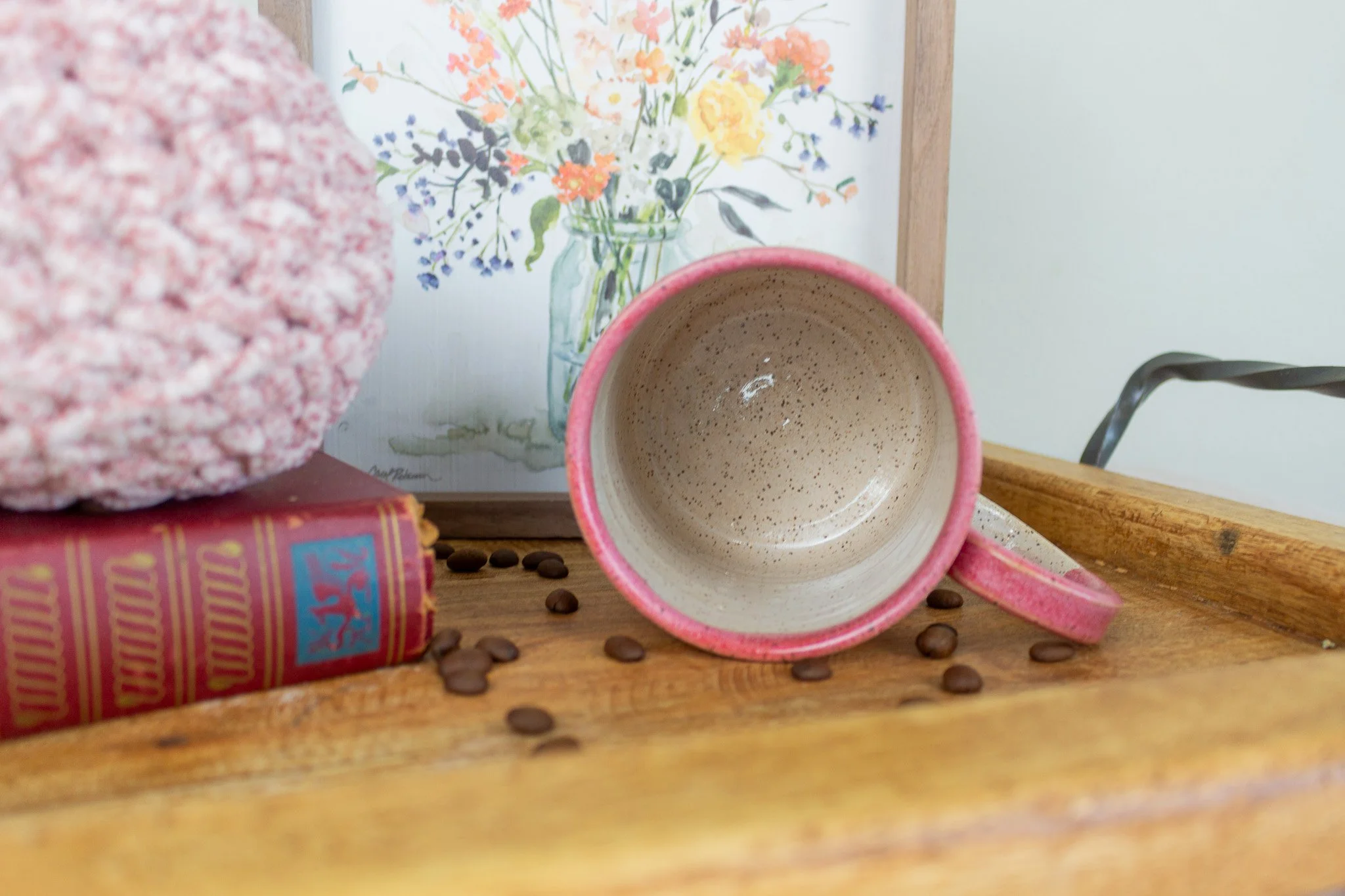 empty mug laying on its side showing cream and speckled interior.