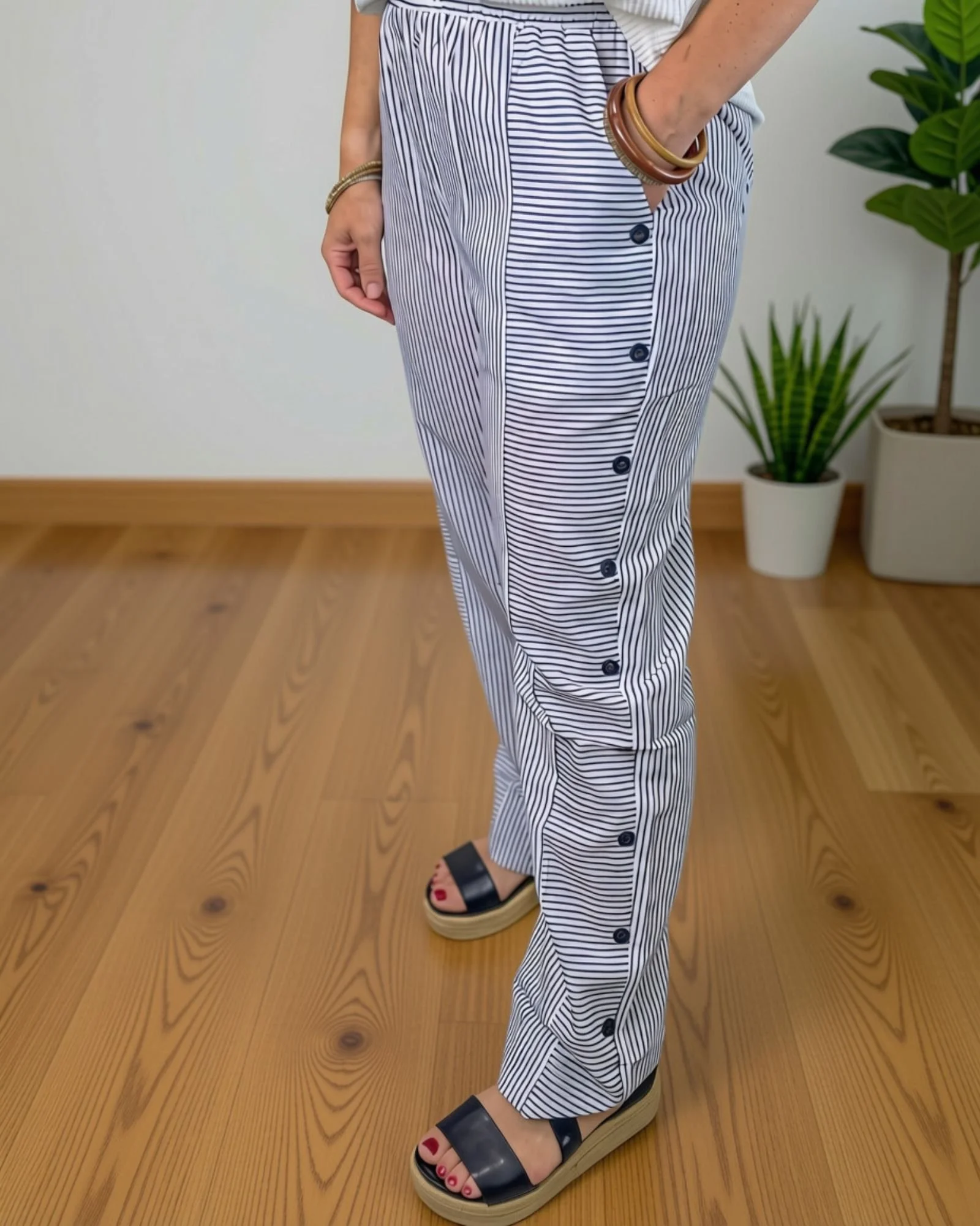 white and dark gray striped pants with faux buttons down each side.