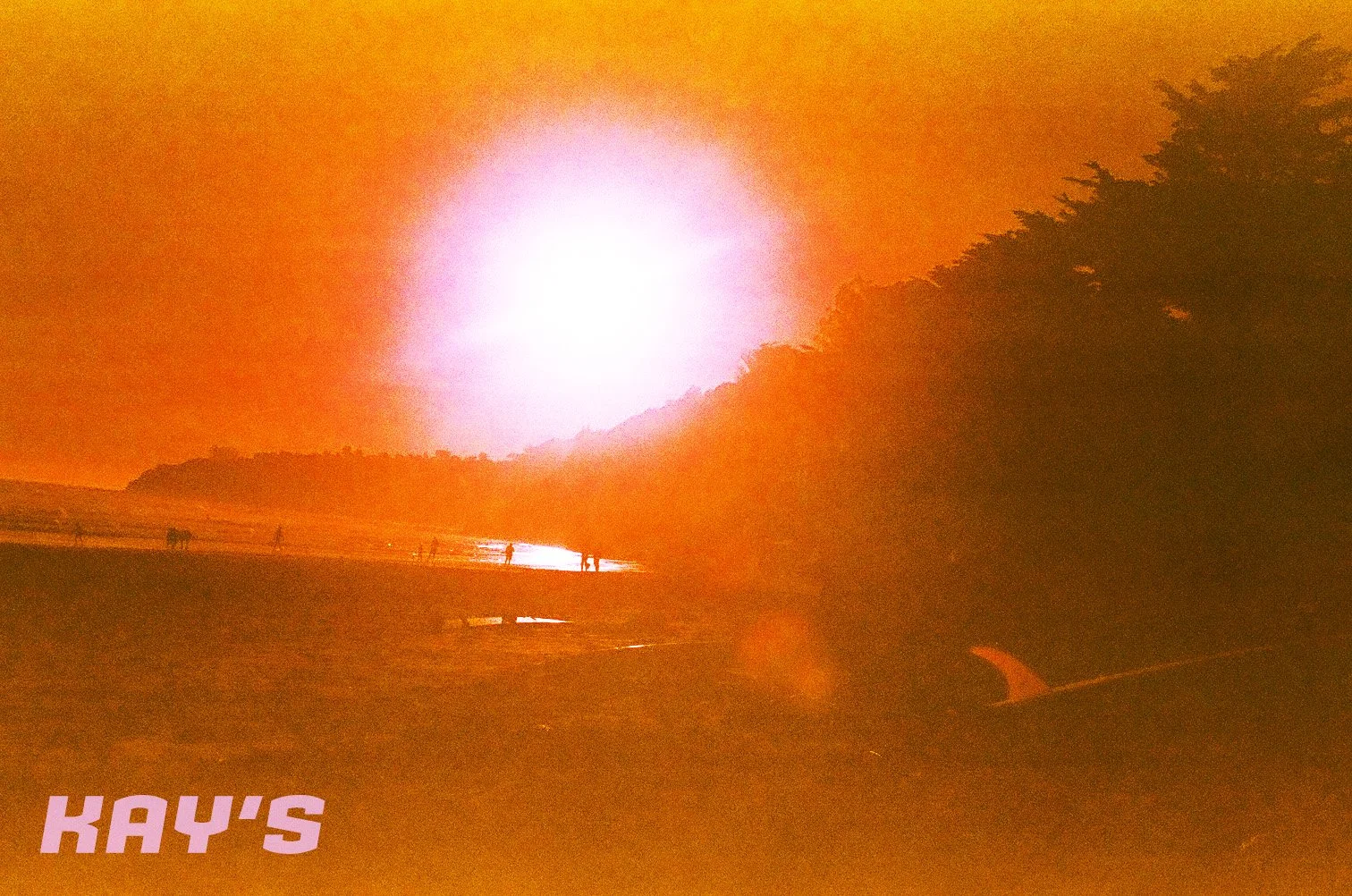 Sunset over a beach with silhouettes of people walking and trees in the background, and the text "KAY'S" in the lower left corner.