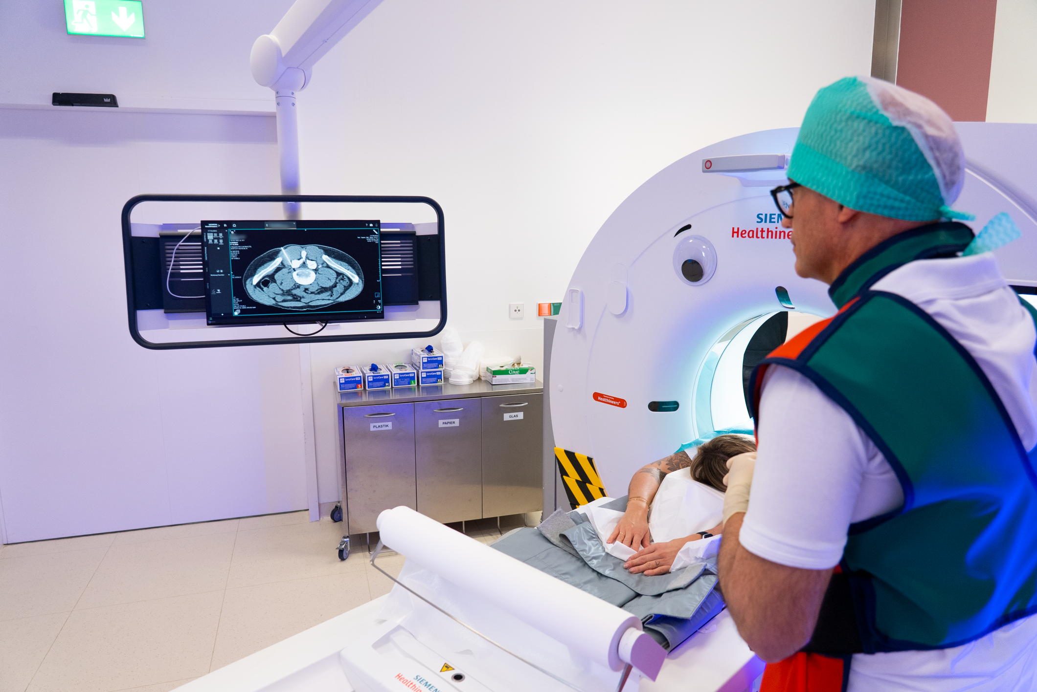 Ärz beim Durchführen einer CT-Untersuchung an einer Patientin im Krankenhaus.