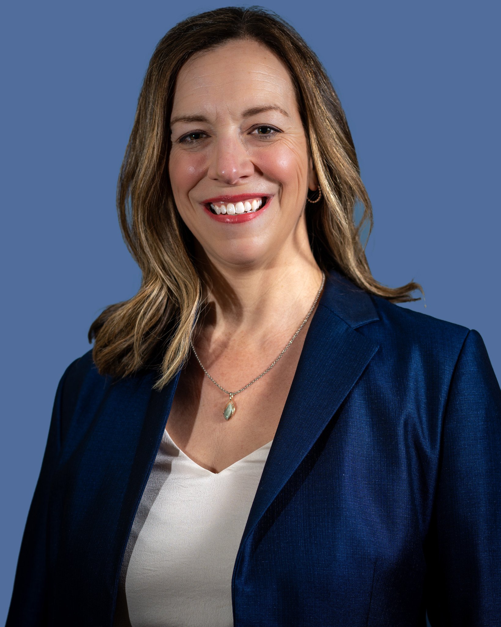 Jenni Henry, Principal at Level Up Fundraising Strategies. A woman in a blue blazer smiling at the camera