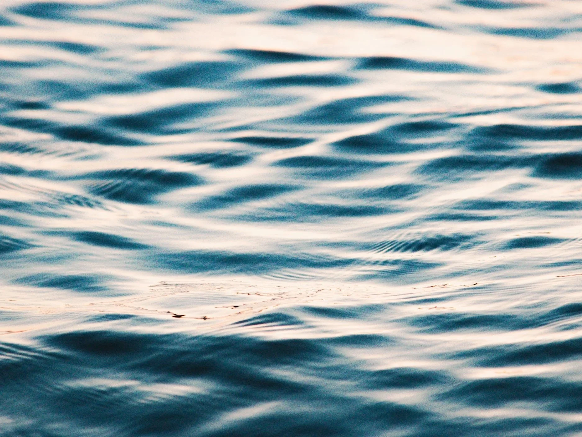 Close-up of a calm body of water with gentle ripples reflecting sunlight.