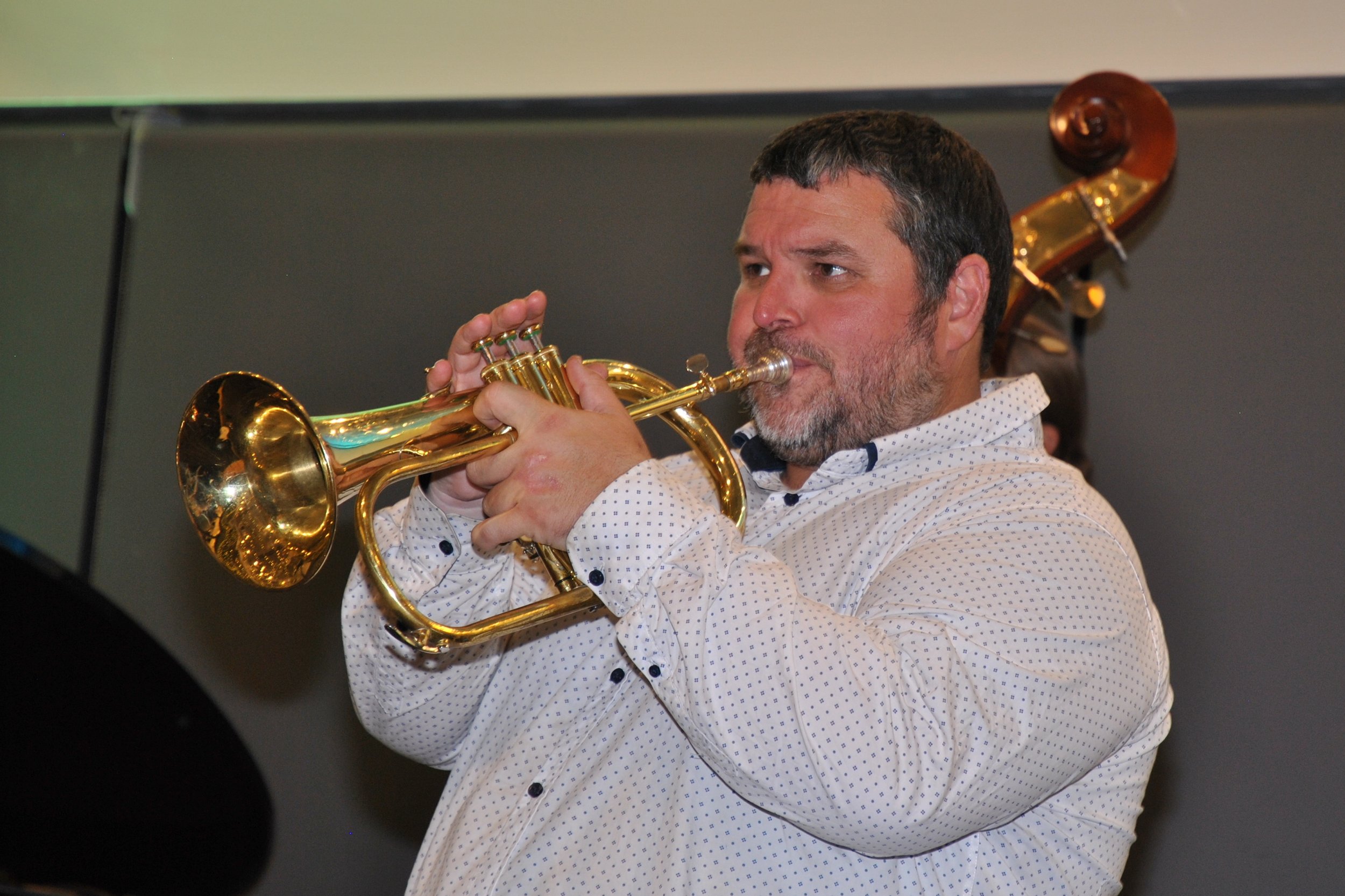 Man playing a trumpet at a music performance.