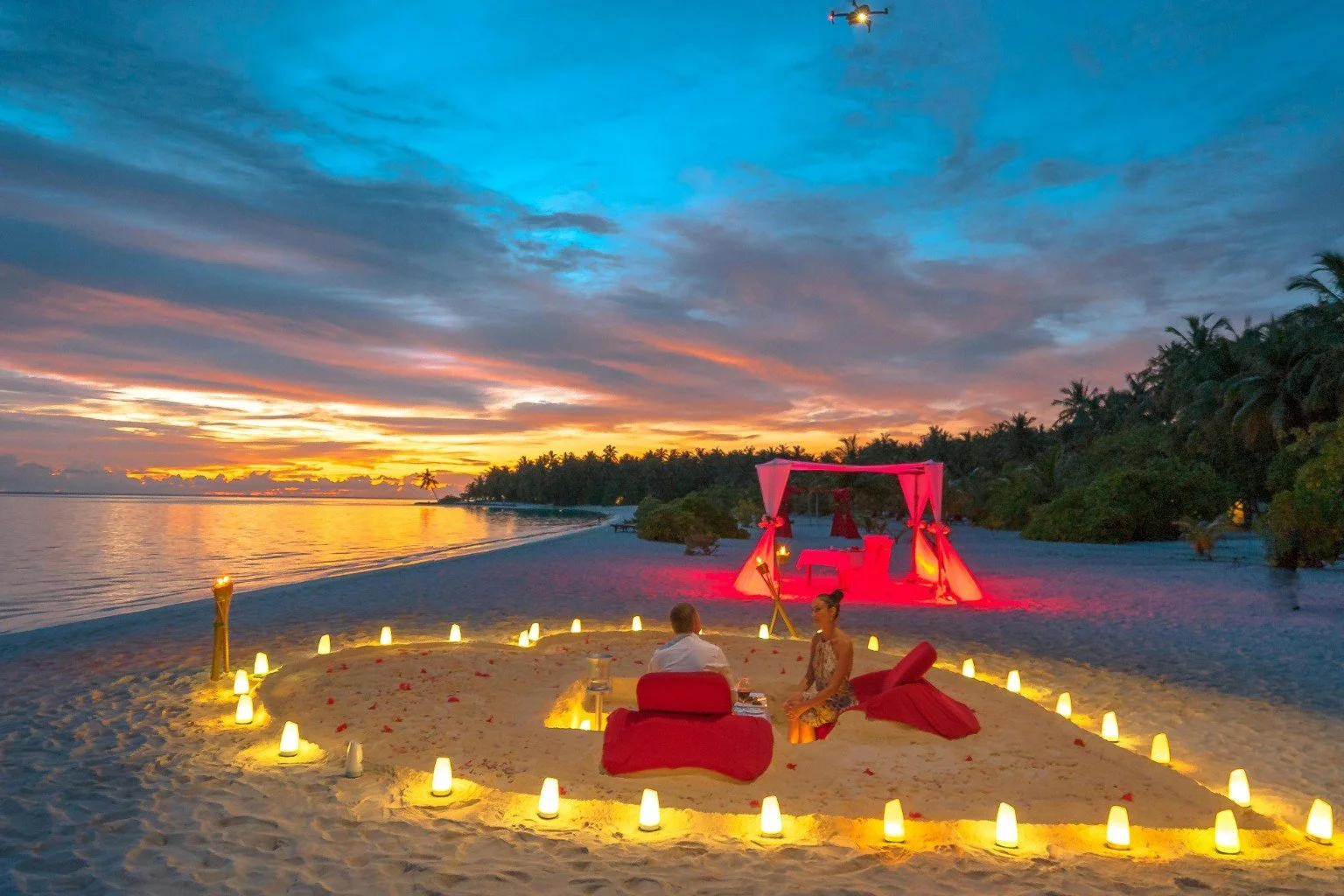 A romantic candlelit beach setting at sunset