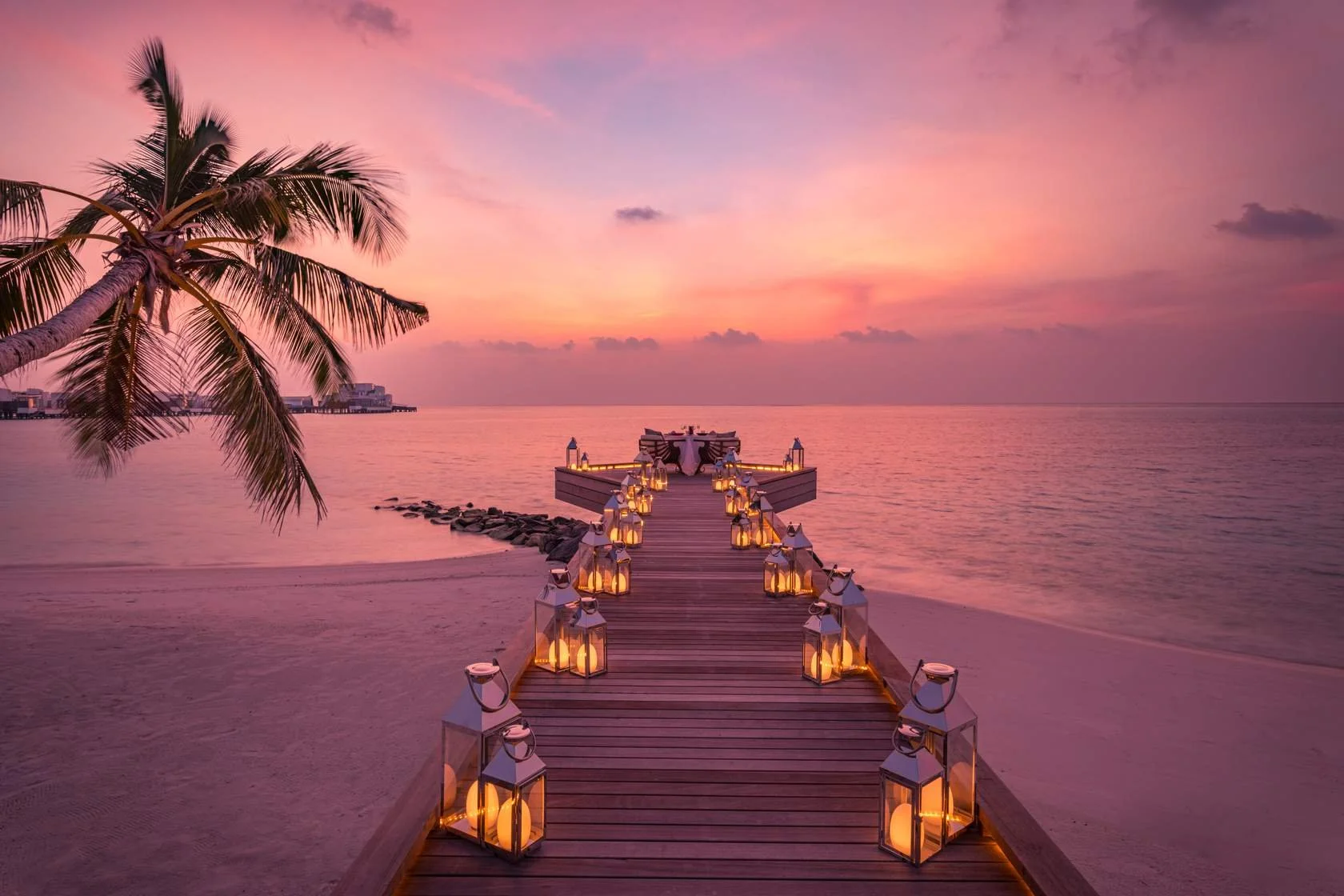 A lantern-lit romantic dinner on a pier at sunset