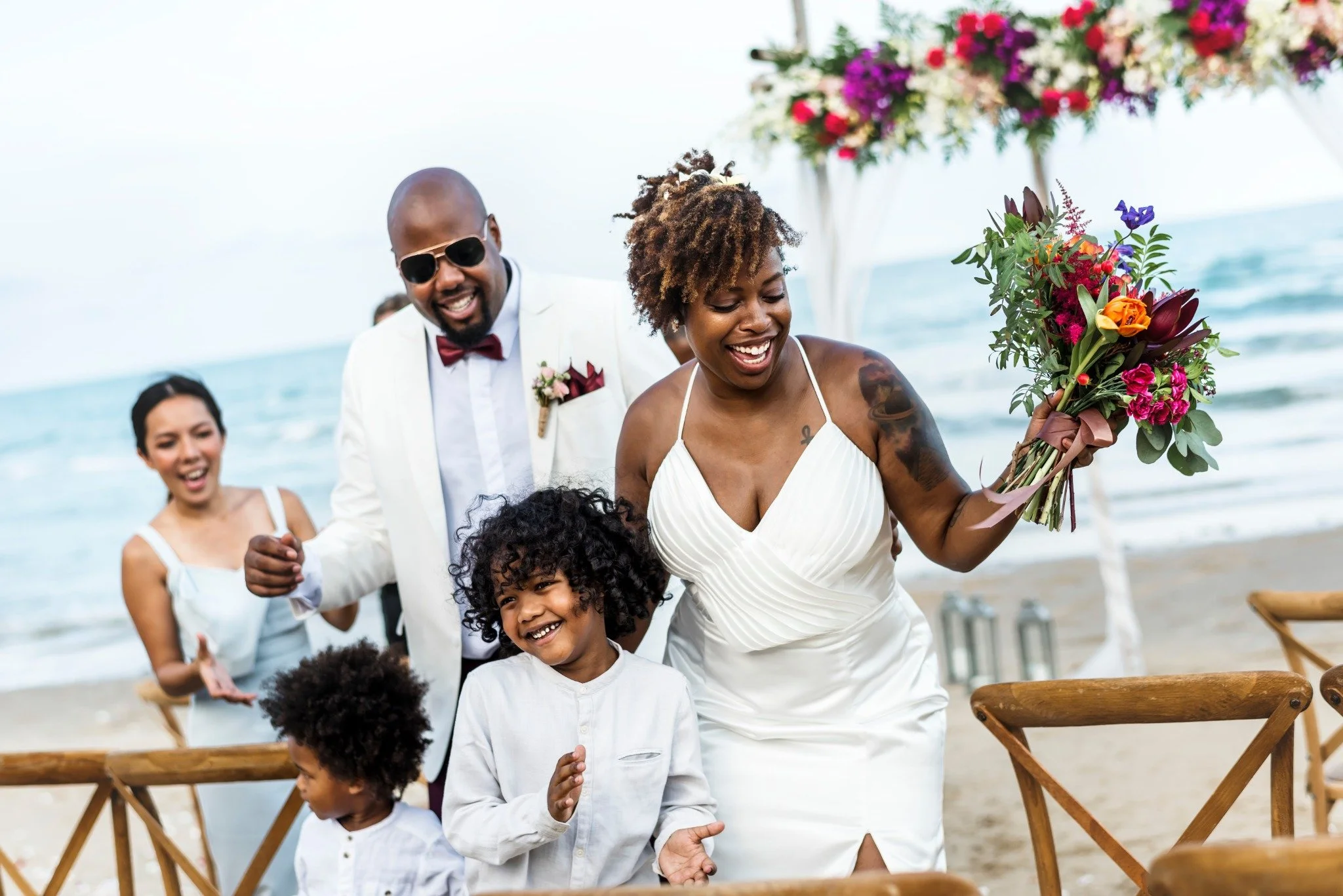 A couple celebrating their beach wedding with family