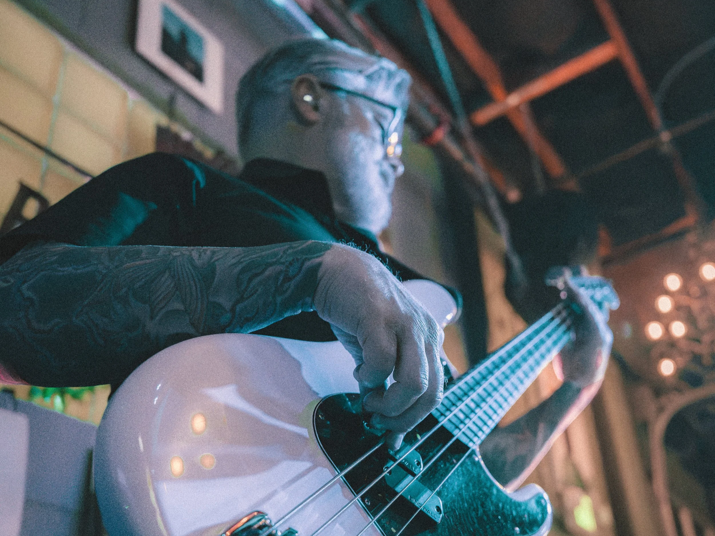Close-up of Kip Lohr playing bass guitar onstage.