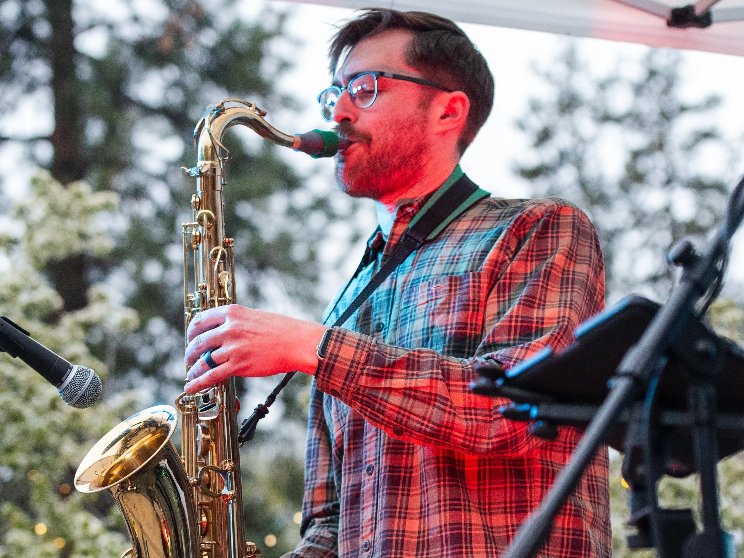 Zach Harju playing saxophone during an outdoor performance.