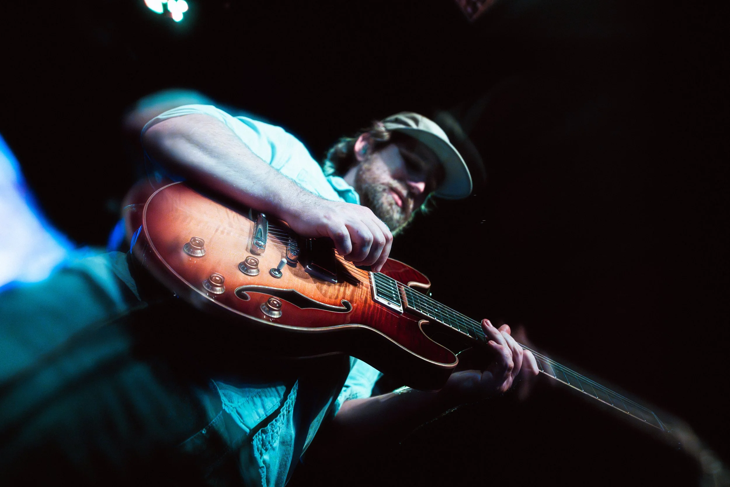 Dan Hiss playing lead guitar under blue stage lighting.