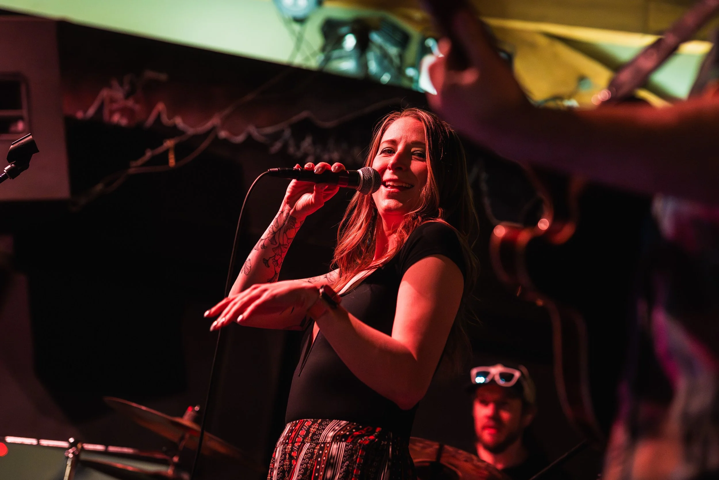 Liz Bauer singing lead vocals during a live performance.