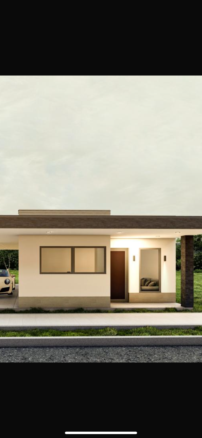 Front view of a modern single-story house with a flat roof and a small front porch. It has two windows, a door with a small window to its right, and a car parked on the driveway to the left. The house is surrounded by green grass and trees.