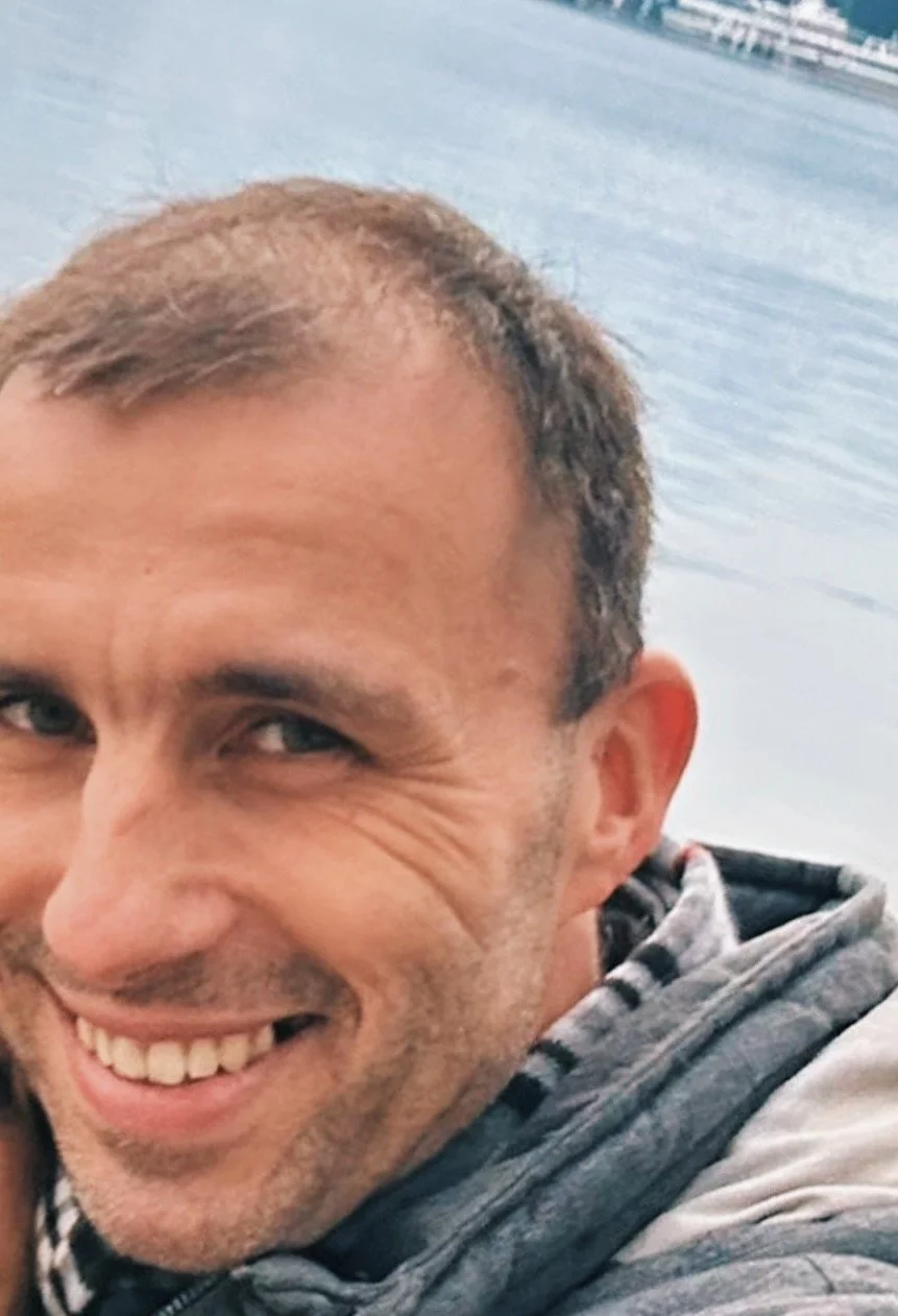 Close-up of a smiling Earthlinks guest with a body of water in the background.