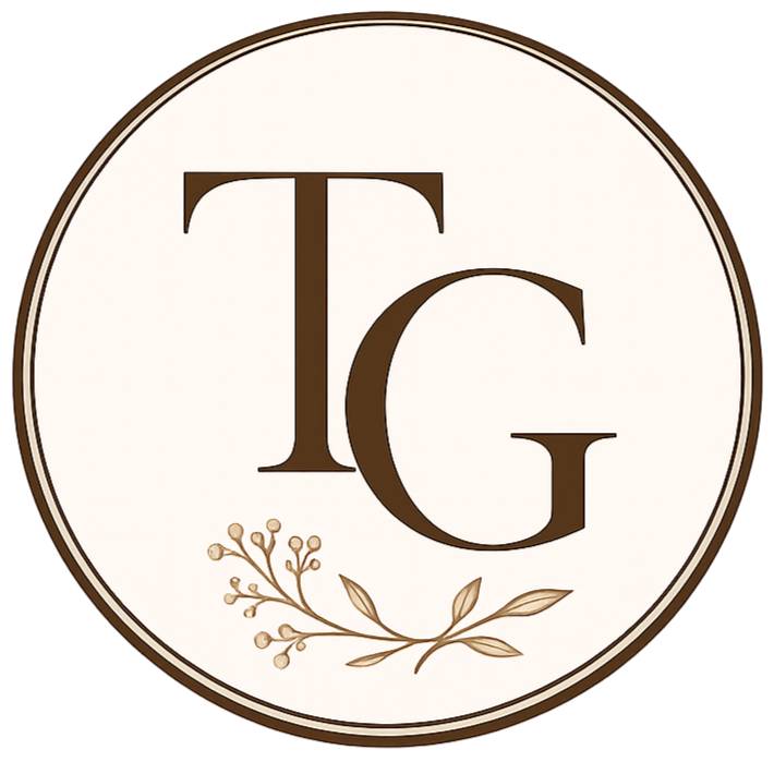 Tahnee Georgia's logo with the initials T and G in brown, and a decorative branch with small leaves and berries beneath the initials, all on a cream background.