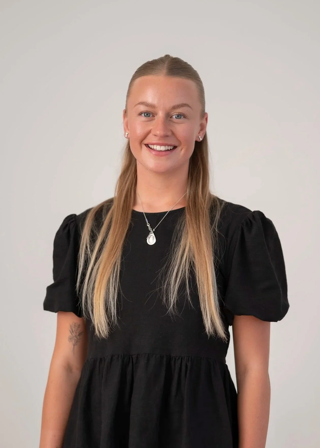 Portrait of Mangaia Fisher, Administrative Lead at Ostend Medical Centre, smiling against a neutral grey background.