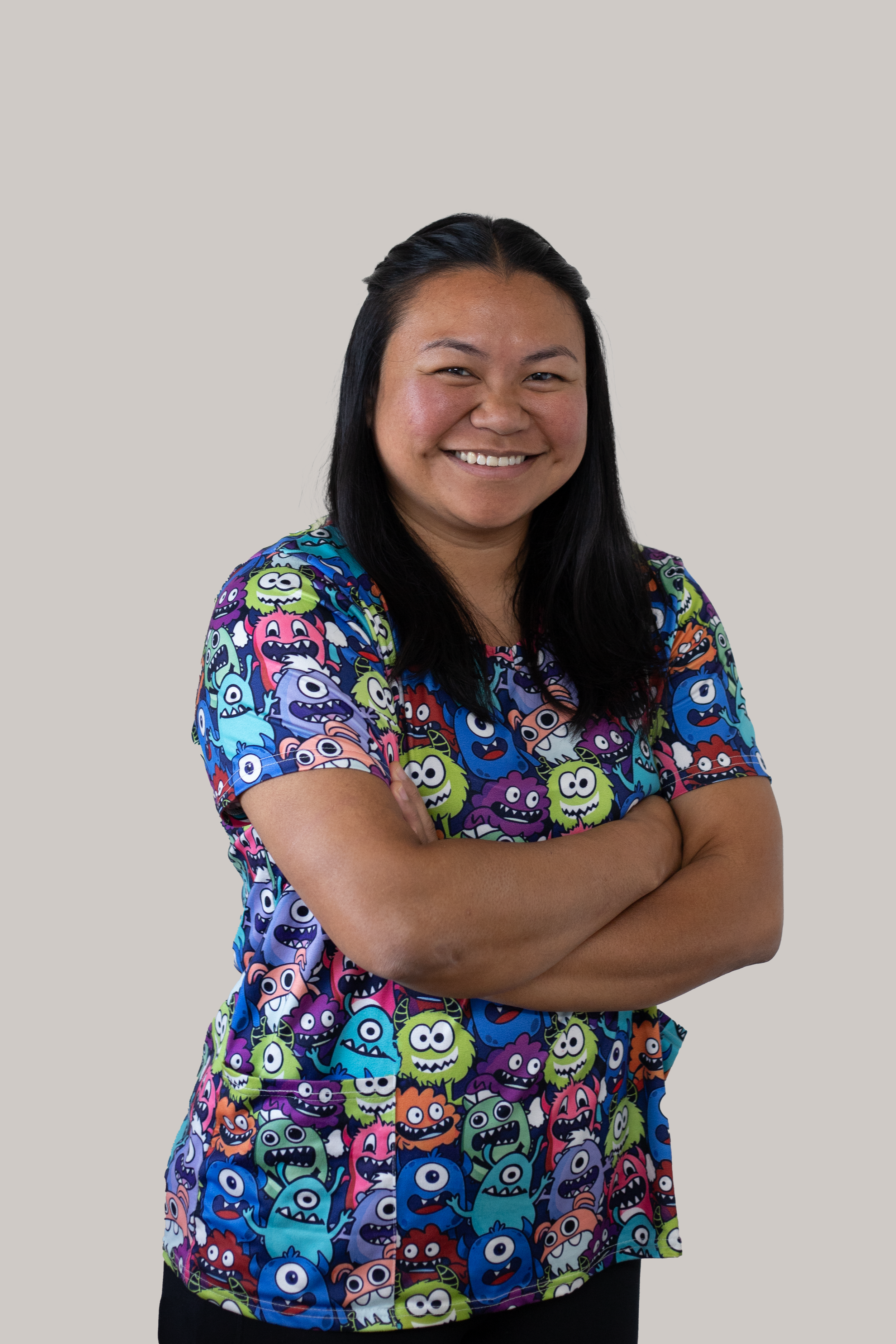 Portrait of Elaine Smart, Well Child Tamariki Ora Nurse, smiling with arms crossed in a colourful patterned clinical top.